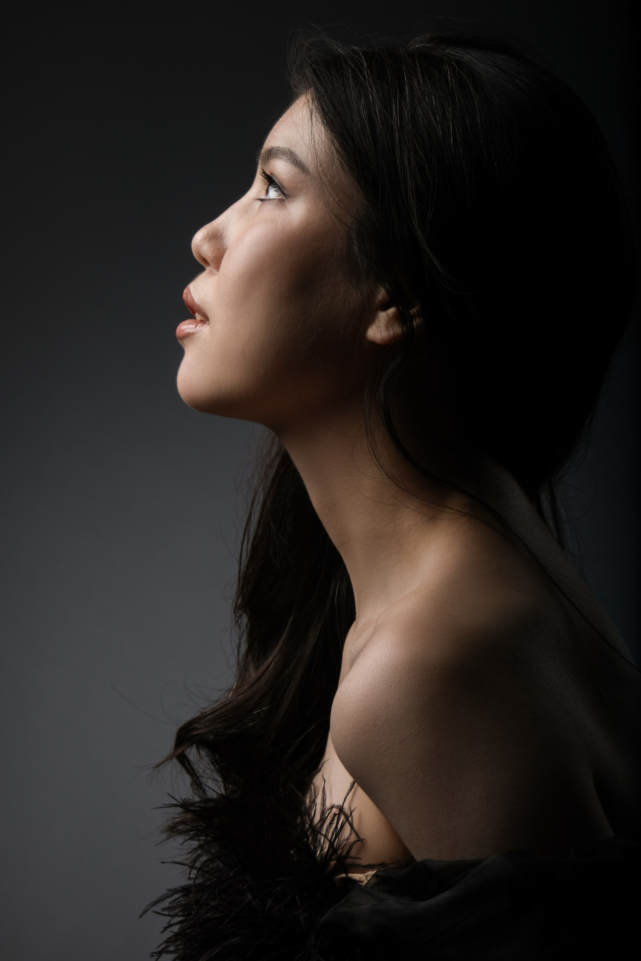 Молодая девушка с нежным выражением лица в тени — портрет в полутени, подчеркивающий мягкость и утонченность женщины.