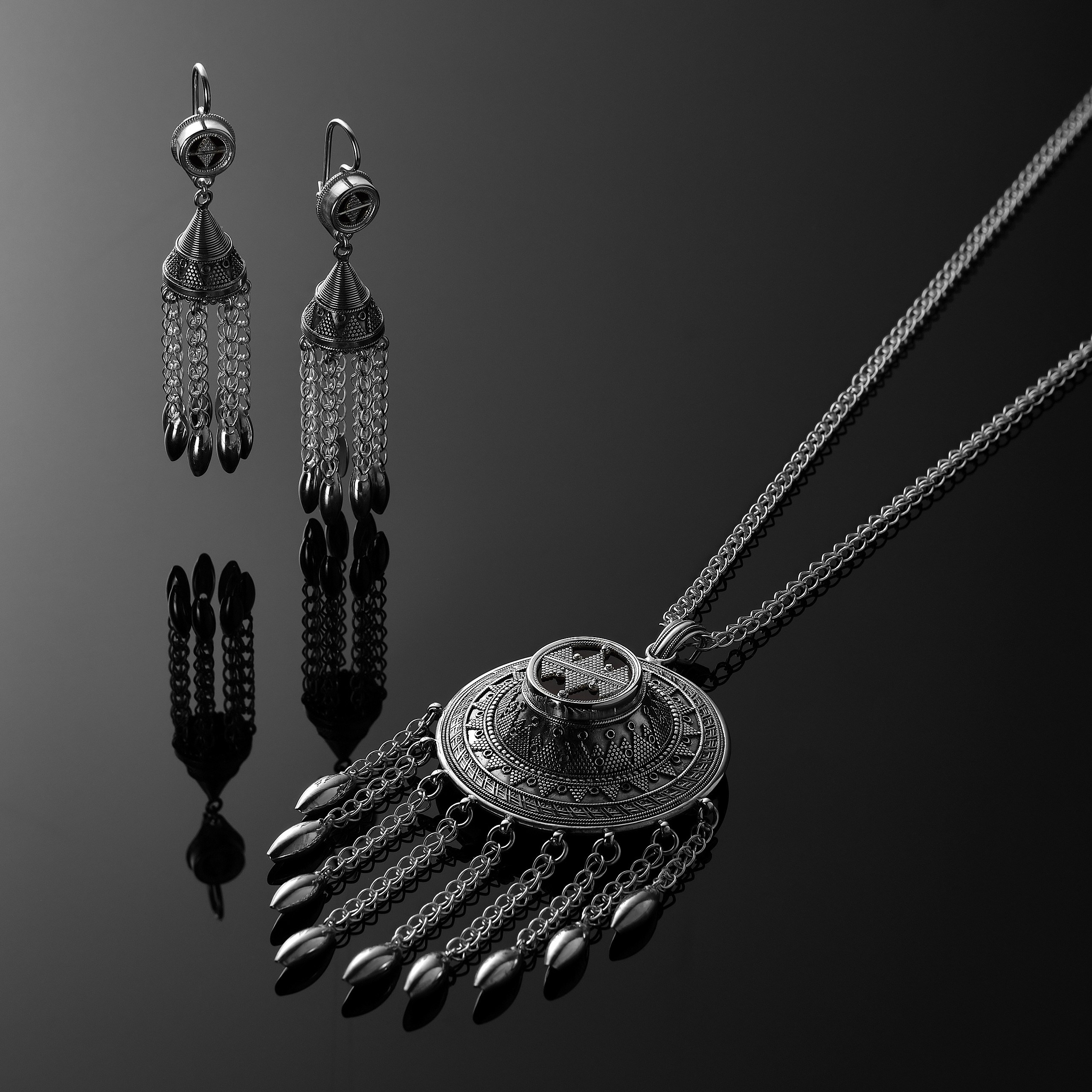 Рекламная фотосъёмка украшений Ornek — комплект серёг и кулона с узорами в стиле казахского орнамента. Студийная съёмка для интернет-магазина.