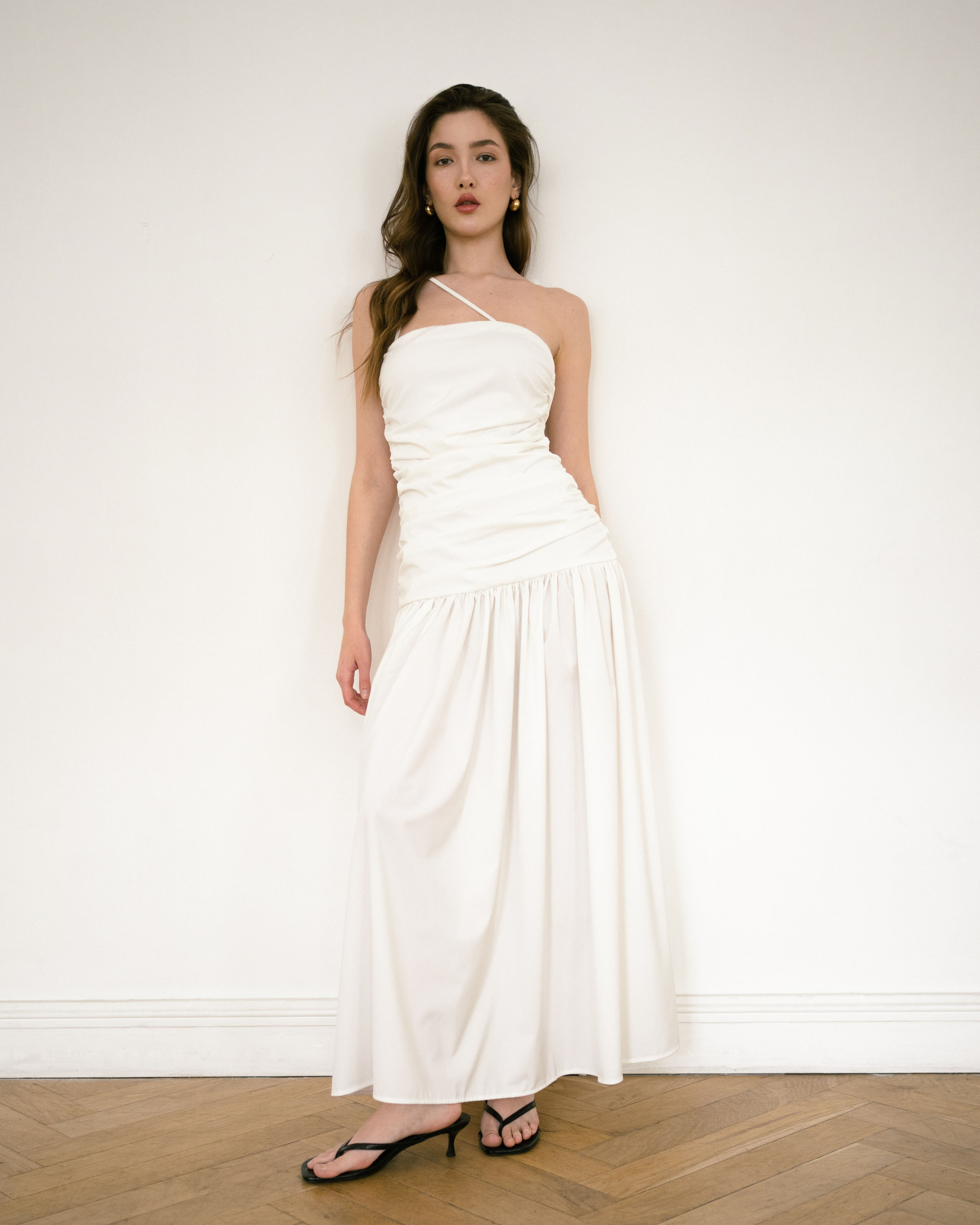 Красивая модель в белом платье на фотосессии для бренда