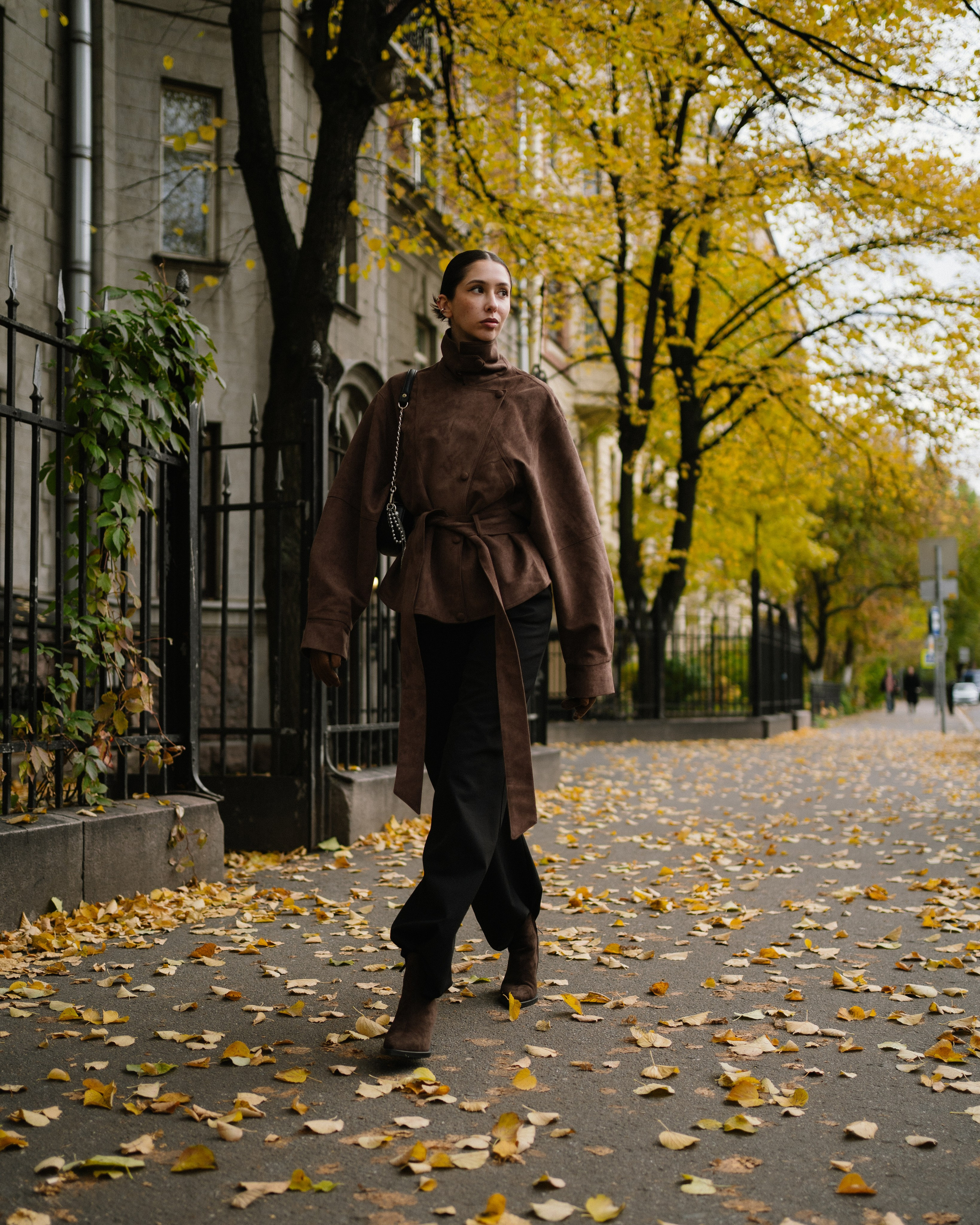 Стильная модель идет по осенней улице