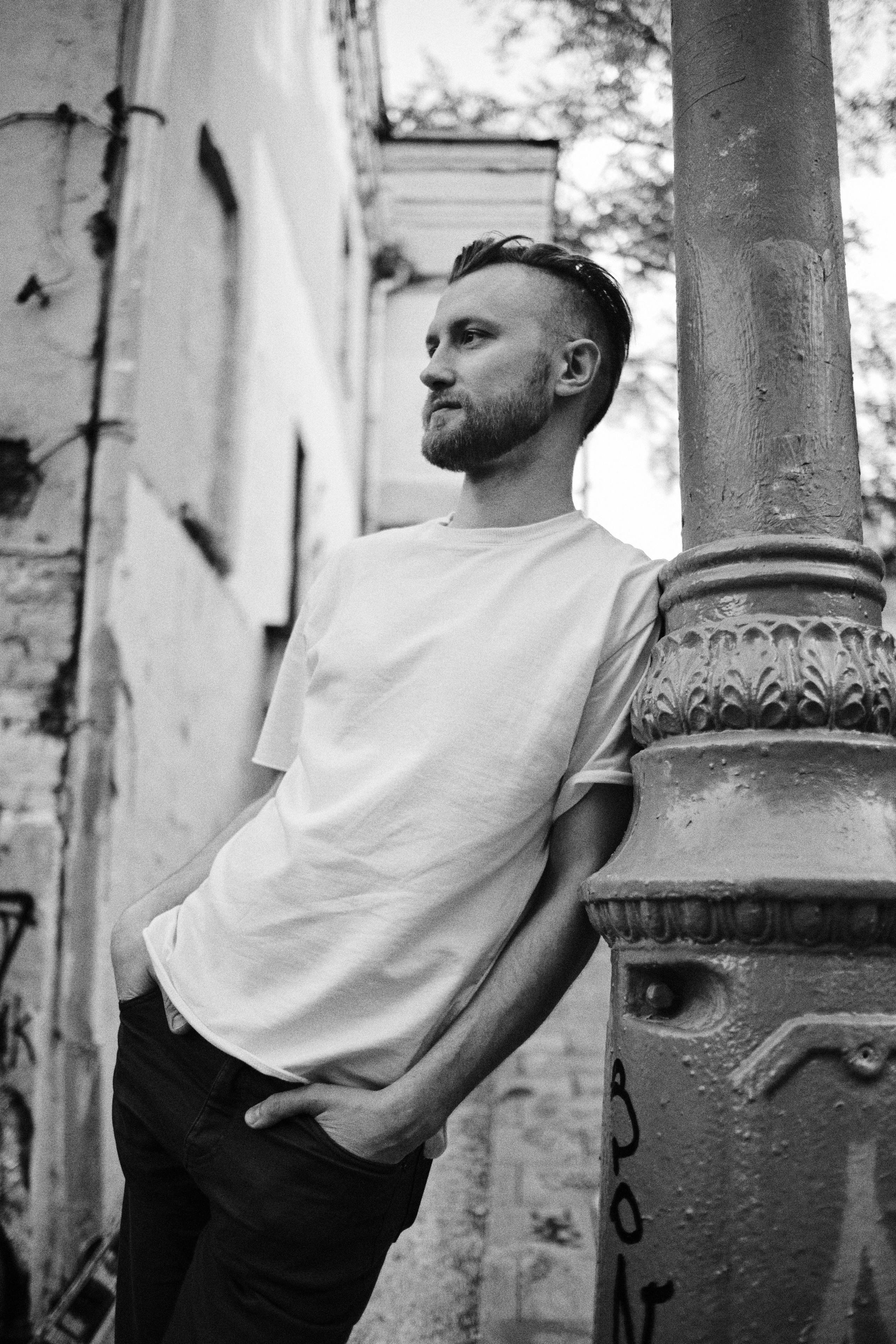 Мужчина на улицах Москвы облокачивается на столб