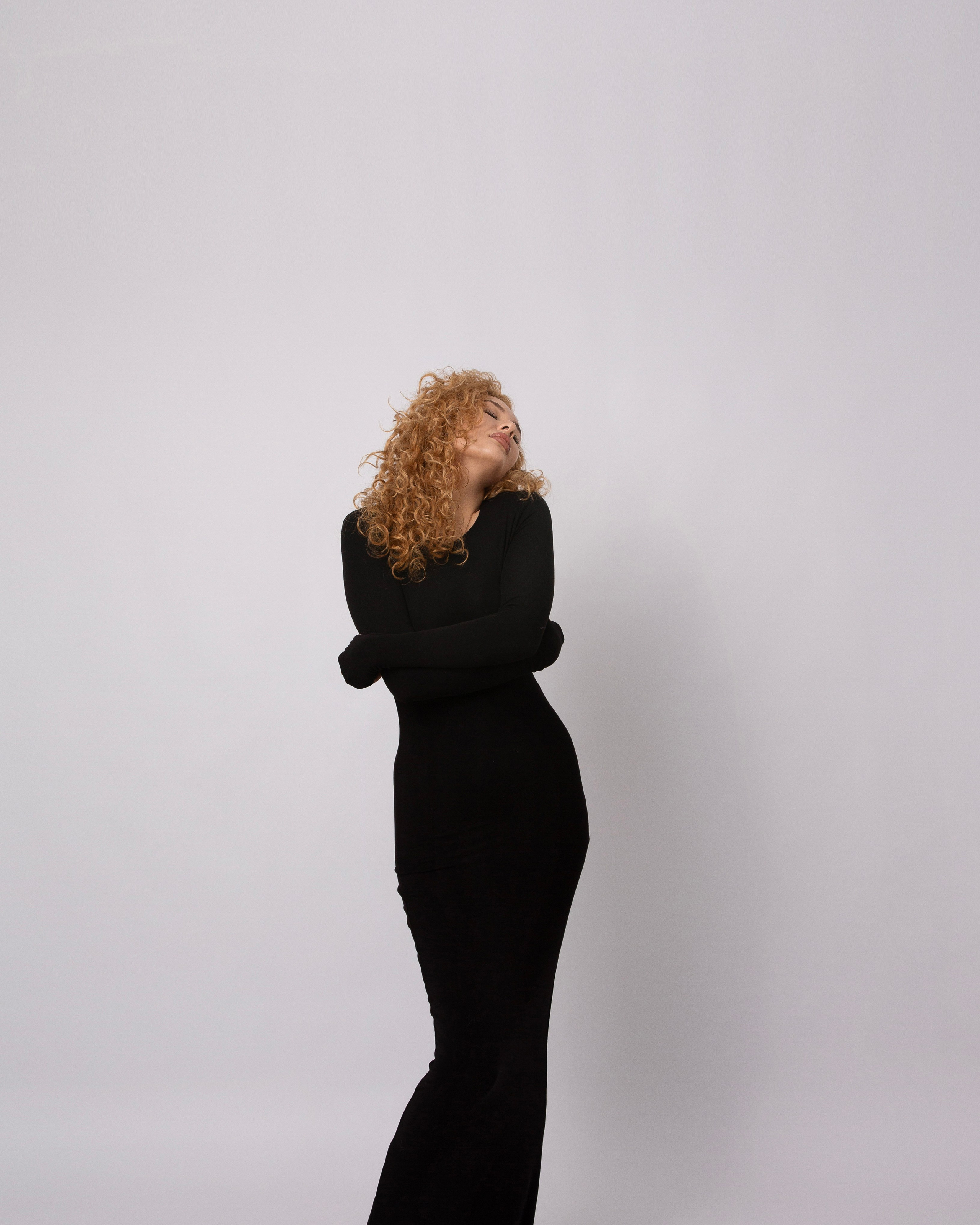 Женщина с кудрявыми волосами, в черном платье Фотостудия в Самаре.