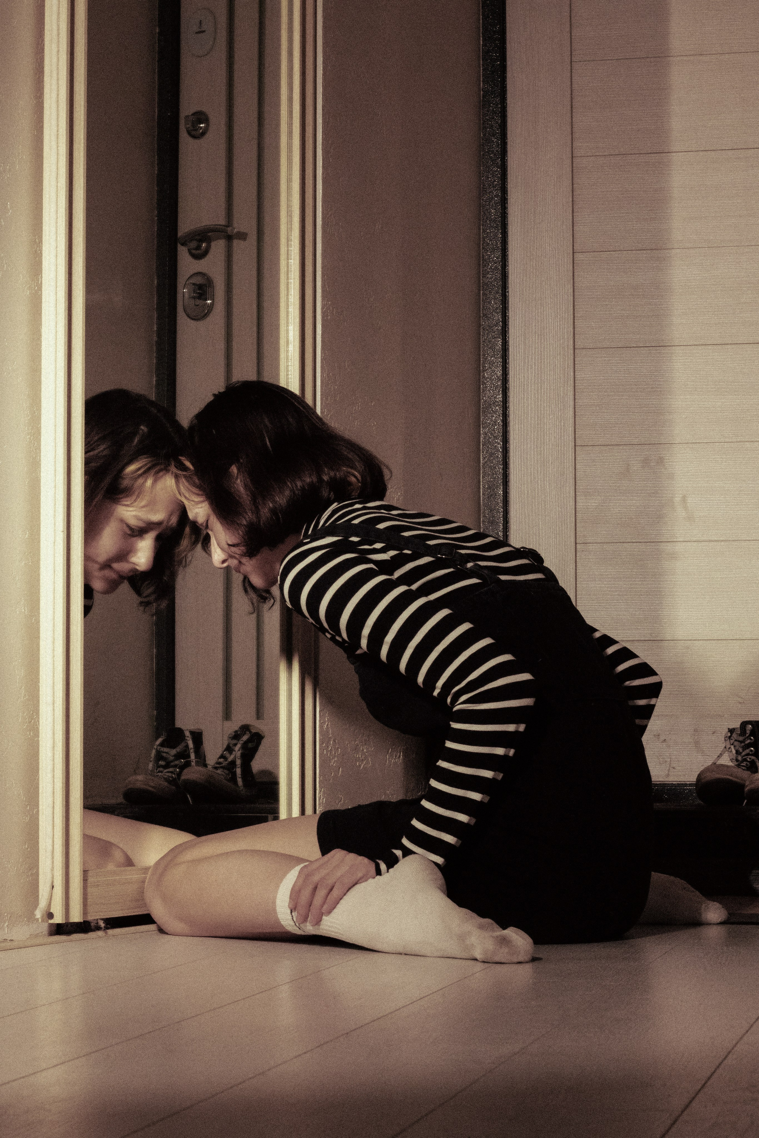 Девушка склонилась к зеркалу, в отражении слёзы и горечь утраты.