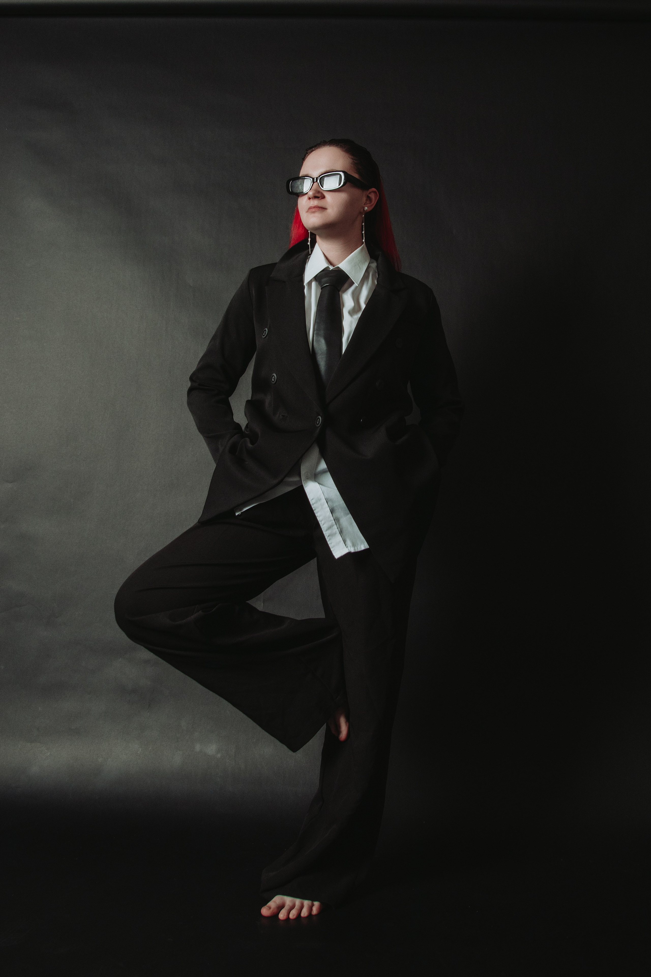 девушка на темном фоне босиком в классическом костюме фотосессия