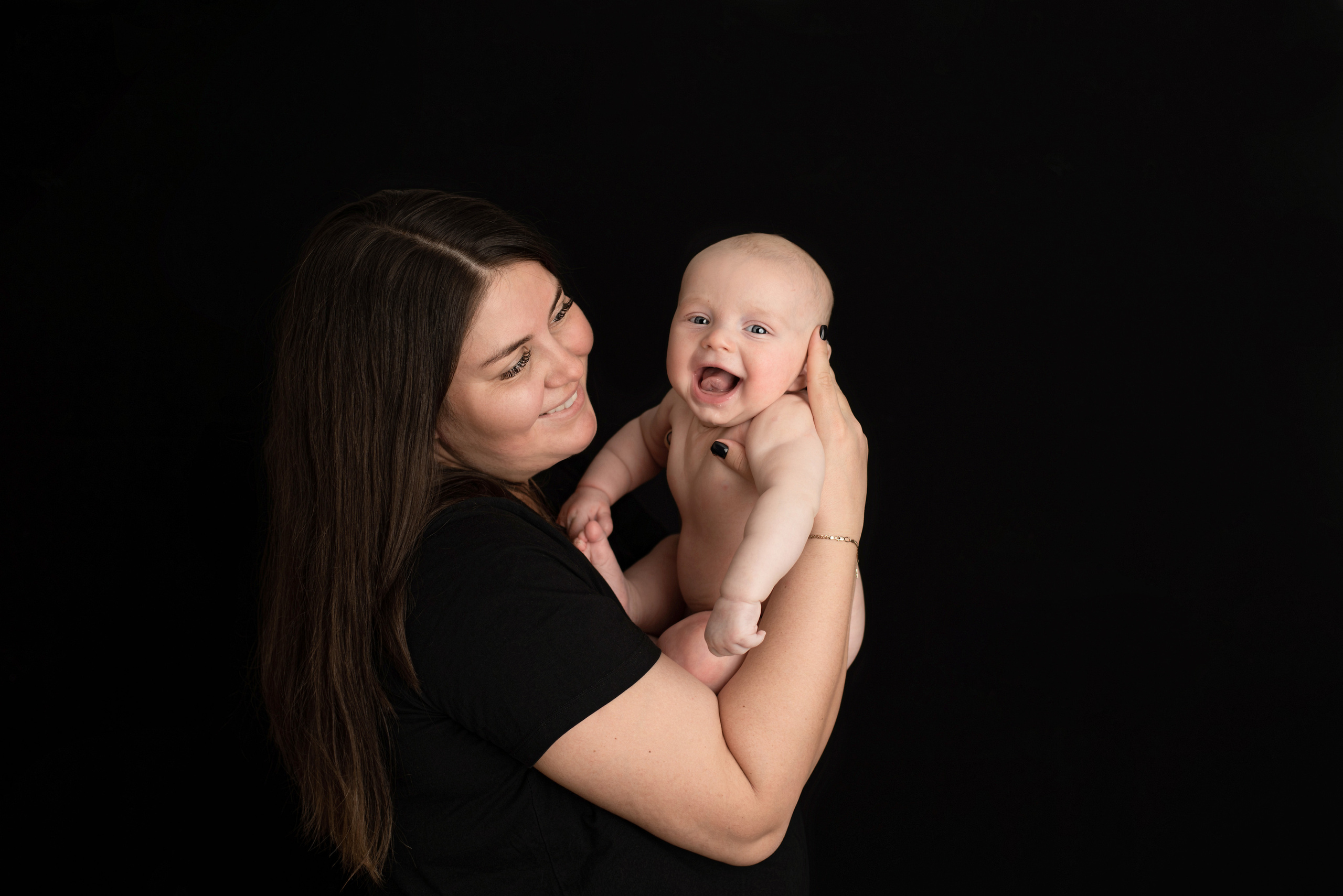 Mom holding a baby on a black background