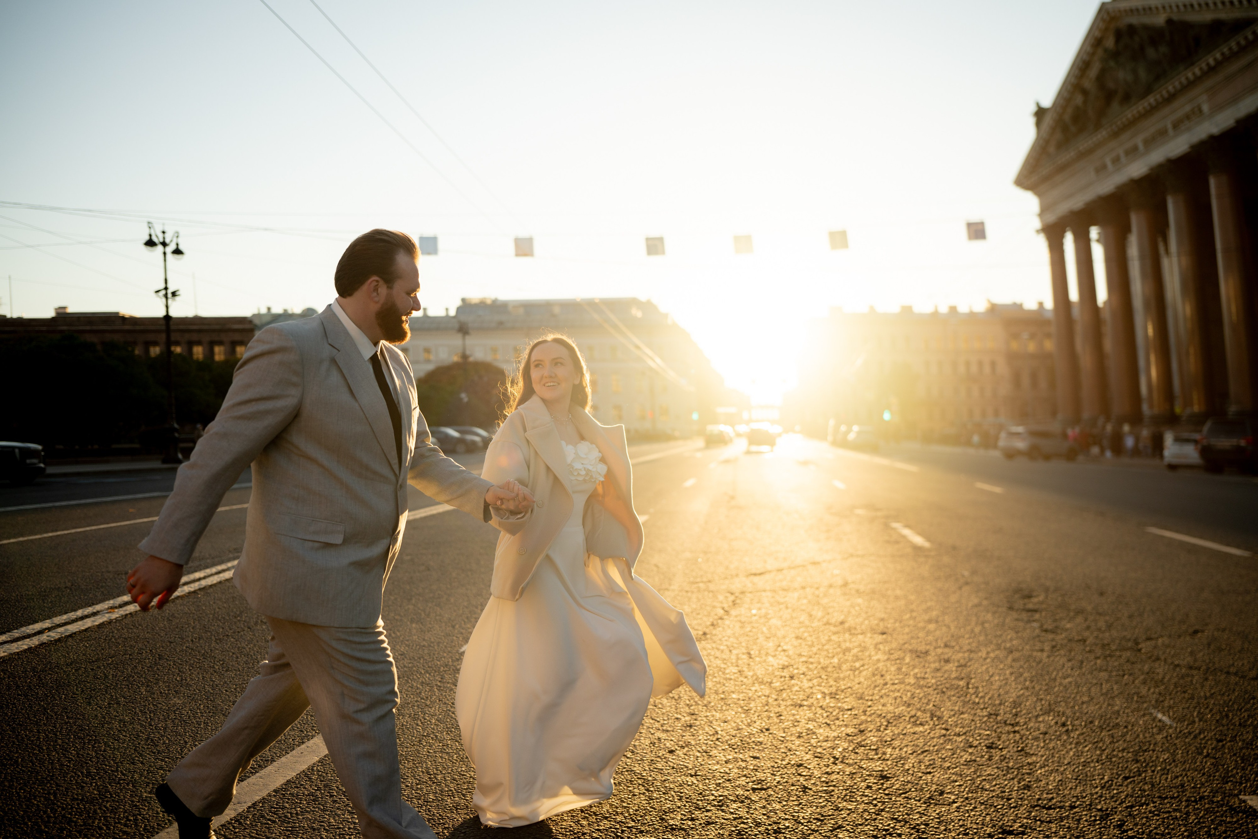 Свадебная фотосессия у Исаакиевского собора на закате жених и невеста бегут в лучах солнца