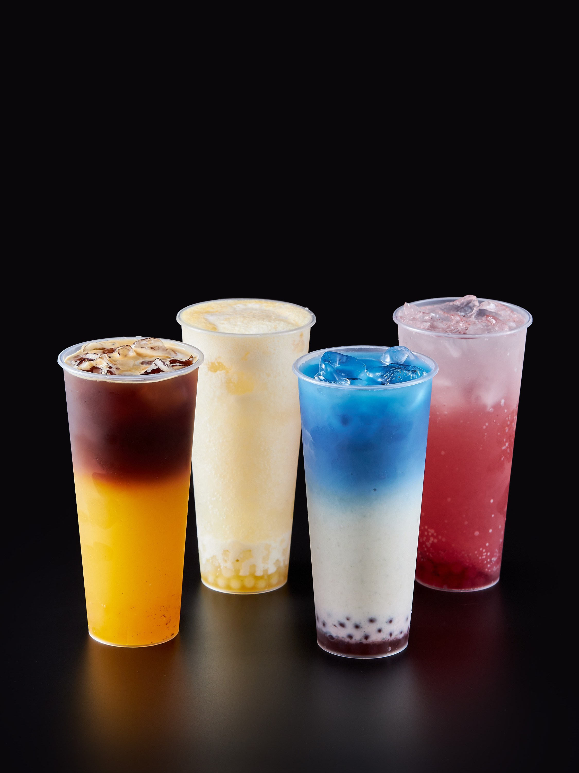 Коктейли 4 пластиковых стакана на черном фоне