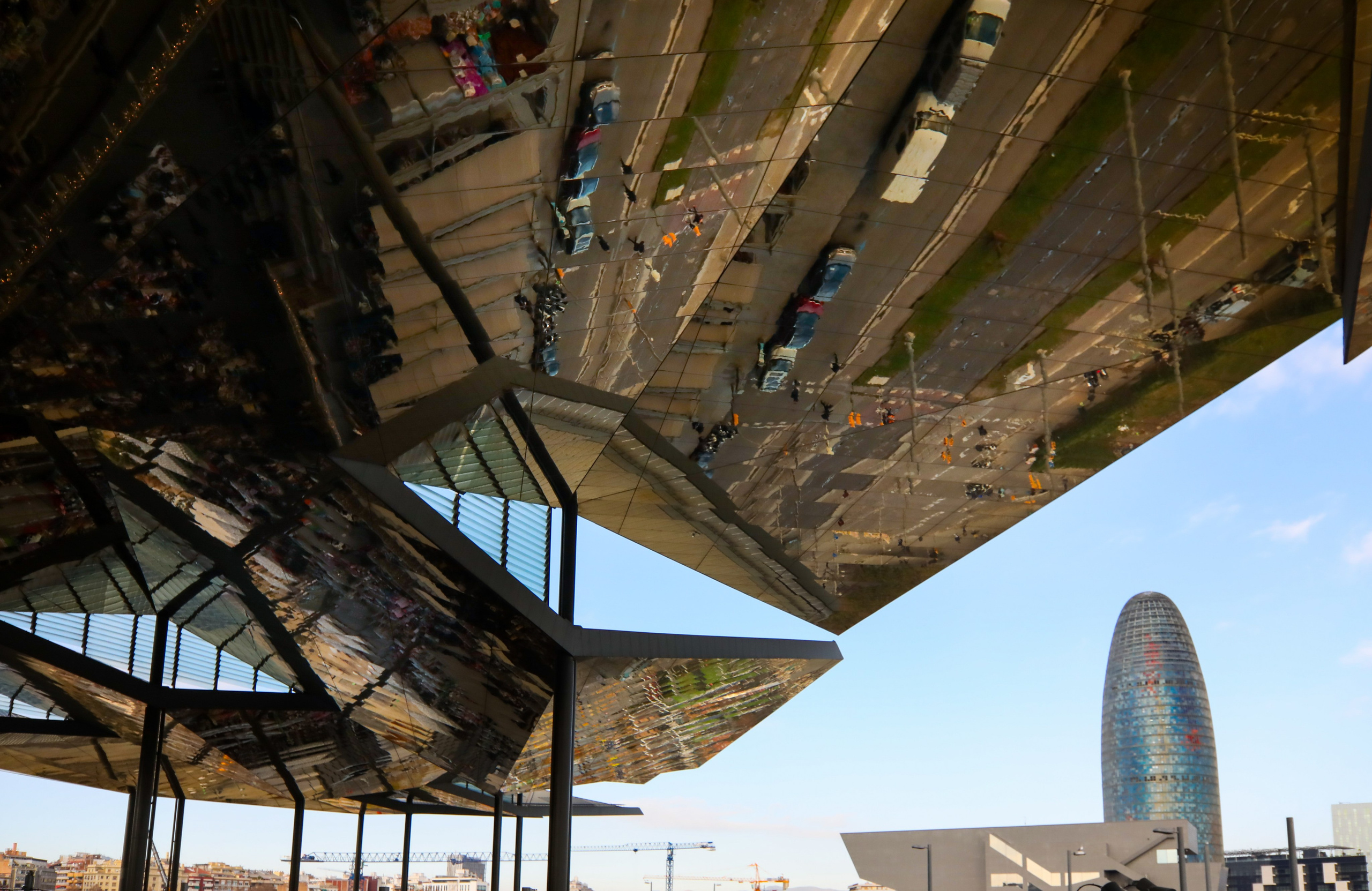 he Mercat dels Encants, Barcelona's famous flea market, with its distinctive mirrored roof and the Torre Glòries (formerly Agbar Tower) in the background, Barcelona, Spain