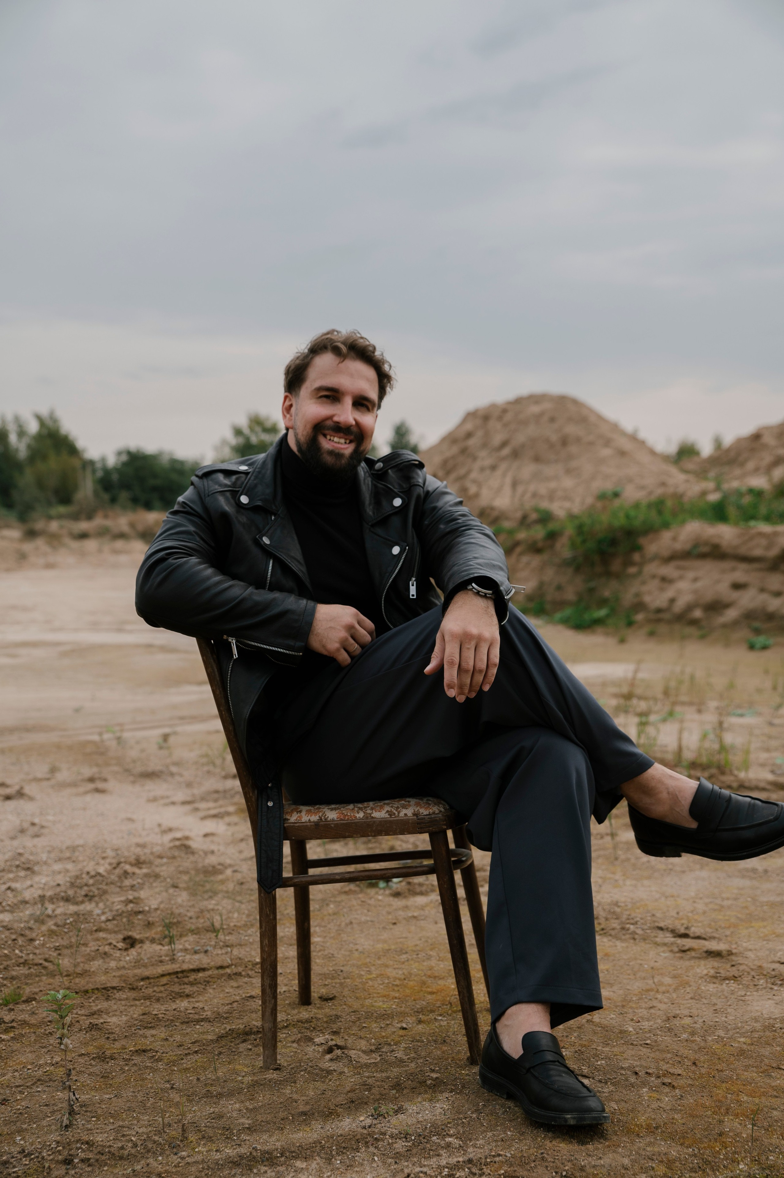 Мужчина на природе, мужчина и пески, фотосессия в дюнах, мужчина на деревянном стуле, мужская поза сидя на стуле.
