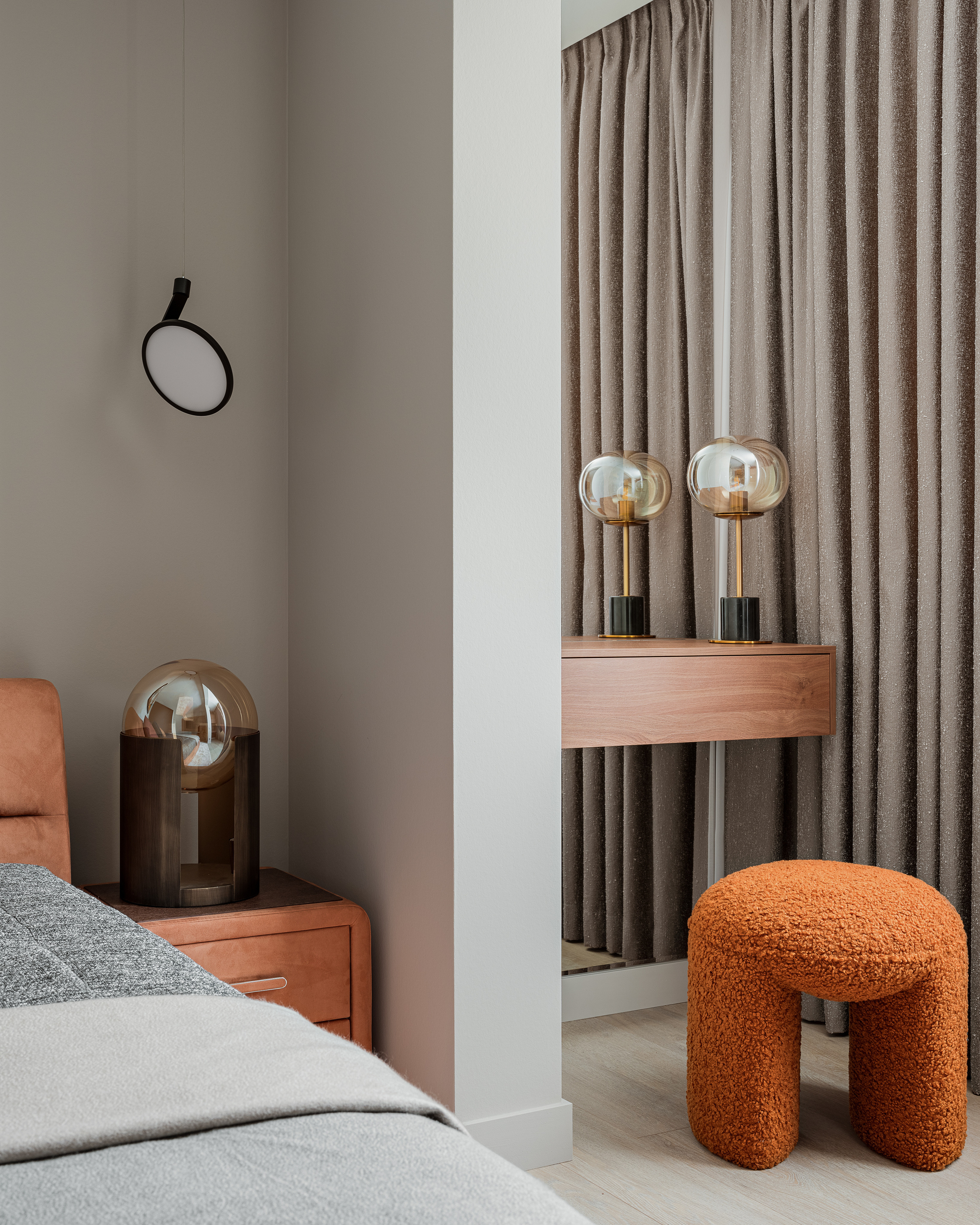 Уютная спальня с серыми текстильными шторами, оранжевым пуфом из букле, деревянной консолью и стильным освещением. Автор дизайна – Алёна Сверлова, фотография Сергея Денисенко.