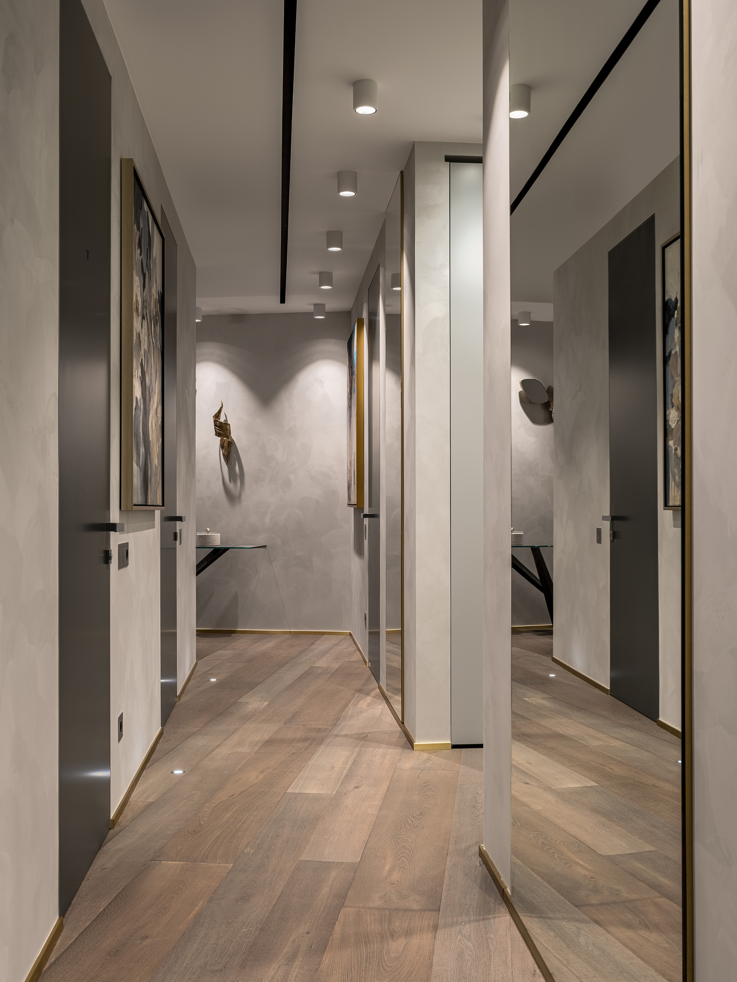 Просторный холл с паркетным покрытием, встроенной подсветкой и современными декоративными элементами на стенах, оформление от Екатерины Ракитиной, интерьерная фотосъёмка Сергея Денисенко.