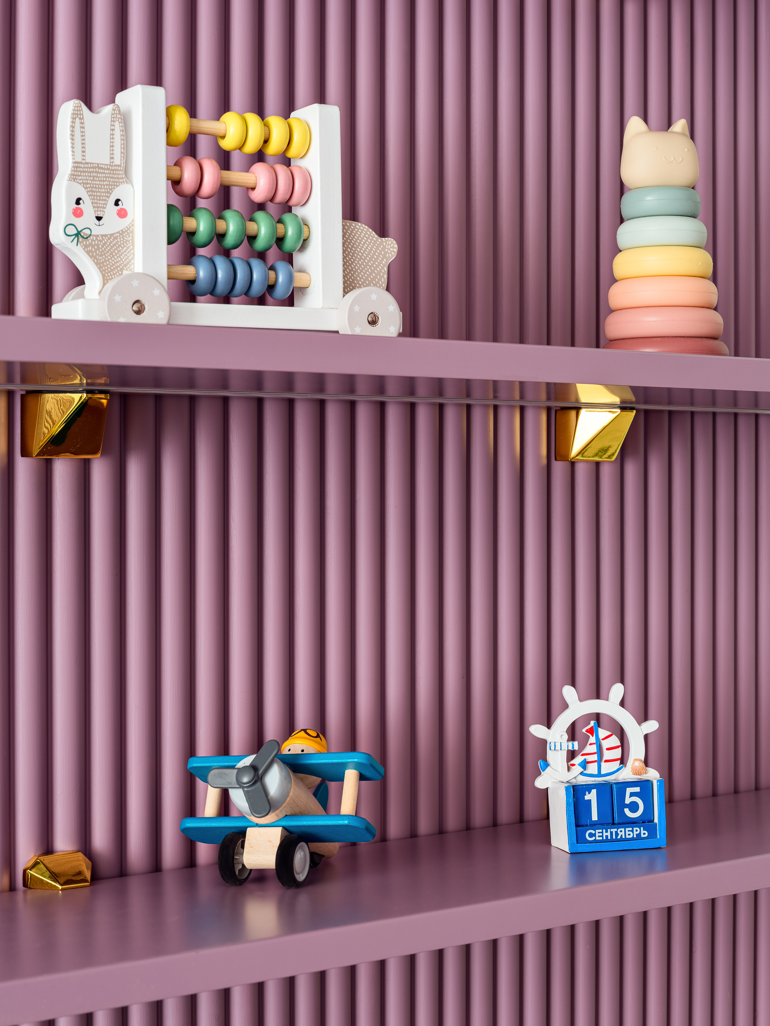 Детская комната с фиолетовыми полками и деревянными игрушками — счёты, пирамидка и самолёт, в современном интерьере, разработанном дизайнером Оксаной Магомедовой, со стилизацией Натальи Якушевой и фотографией Сергея Денисенко.