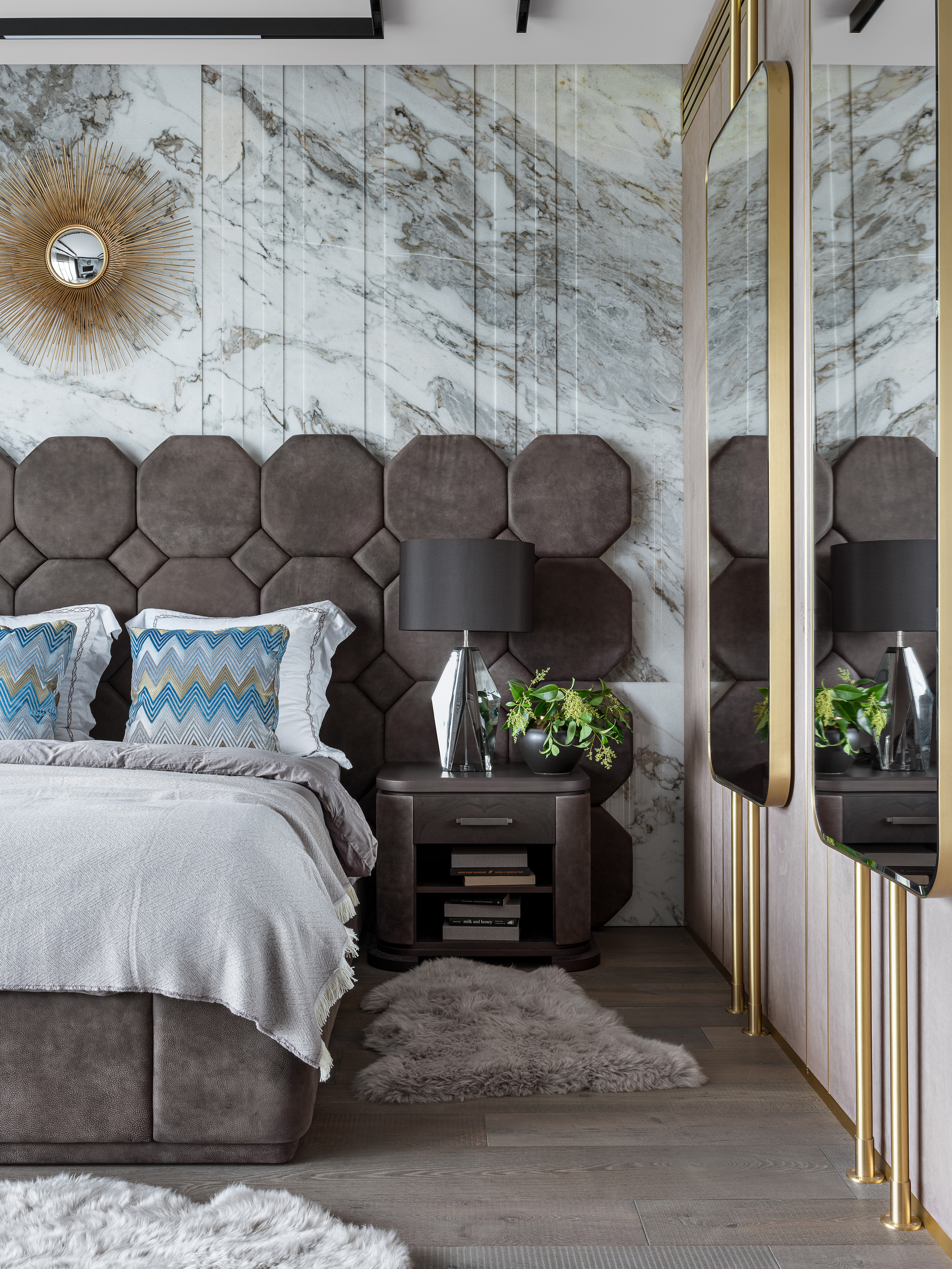 Спальня с мягким изголовьем из геометрических панелей, акцентной мраморной стеной, зеркалами с золотыми деталями и стильными прикроватными тумбами. Стилист Екатерина Ракитина, фотограф Сергей Денисенко.