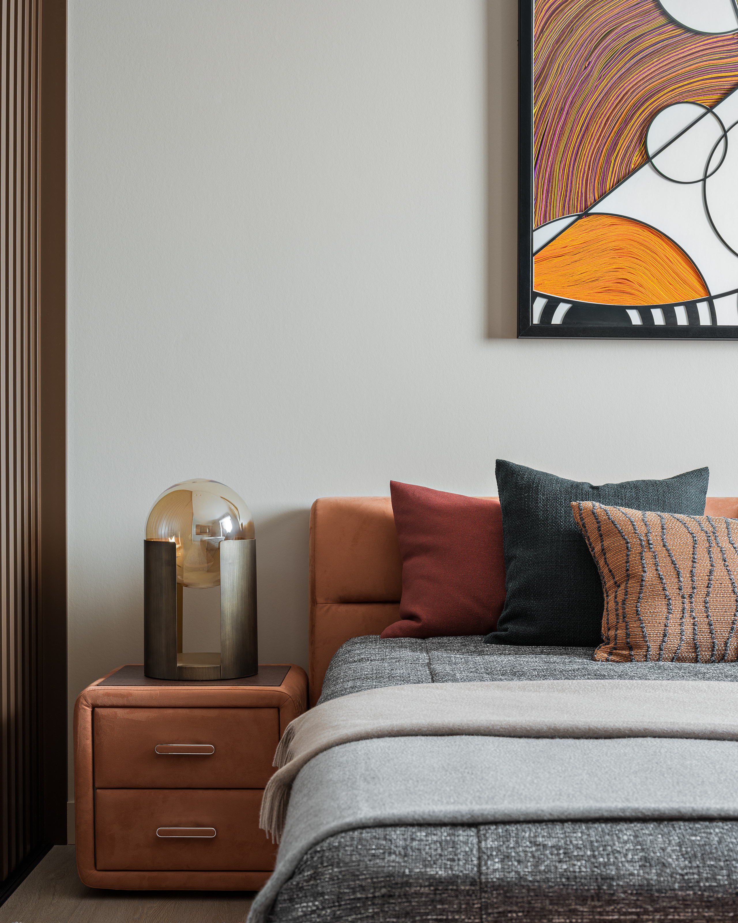 Современная спальня с мягким изголовьем кровати, декоративными подушками тёплых оттенков и яркой абстрактной картиной. Интерьер от дизайнера Алёны Сверловой, фото Сергея Денисенко.