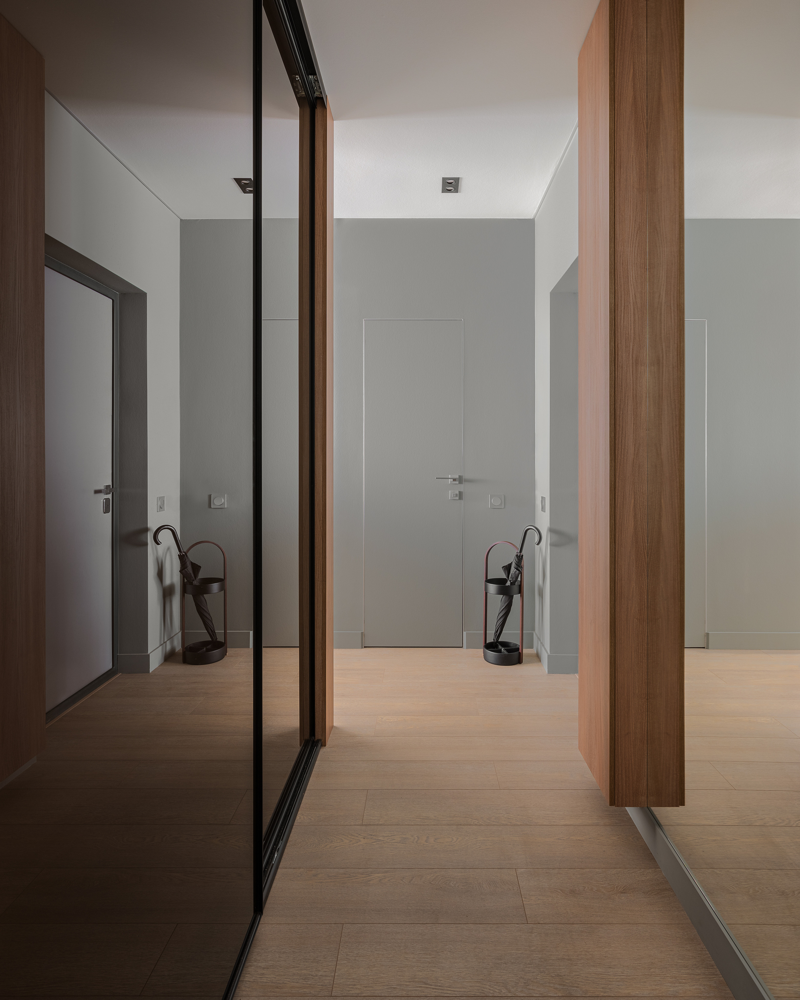 Современная прихожая с большим зеркалом в шкафу-купе, деревянными панелями и зоной для зонтов, минималистичный дизайн от Алёны Сверловой, интерьерная фотосъёмка Сергея Денисенко