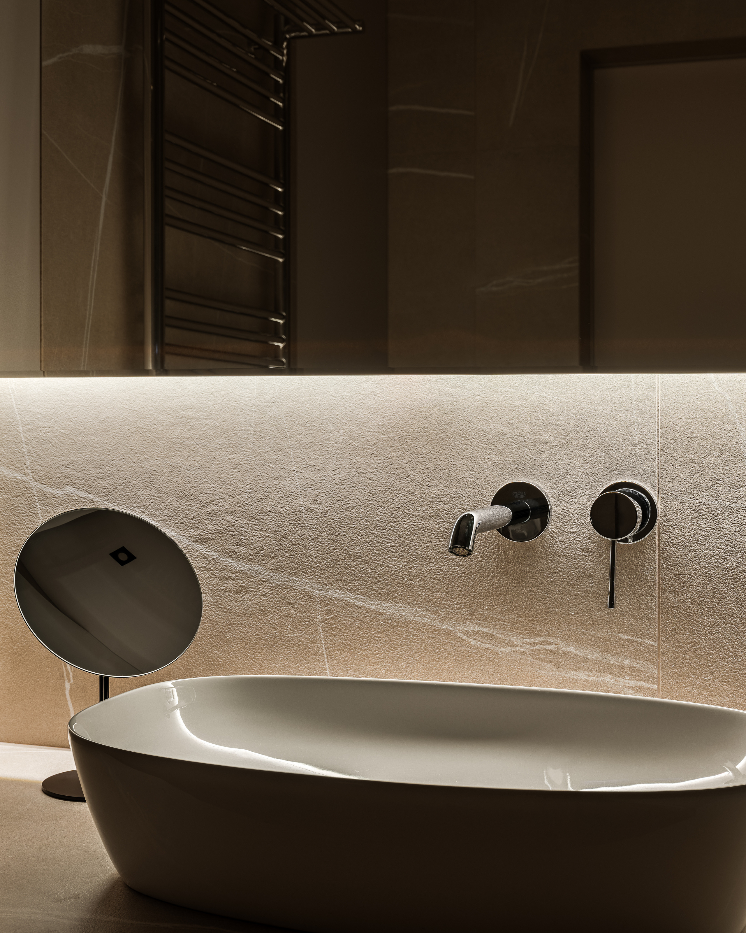 Элегантная ванная комната с прямоугольной раковиной, настенным смесителем и мягкой светодиодной подсветкой на фоне камня, стильный интерьер от Алёны Сверловой, профессиональная фотосъёмка Сергея Денисенко