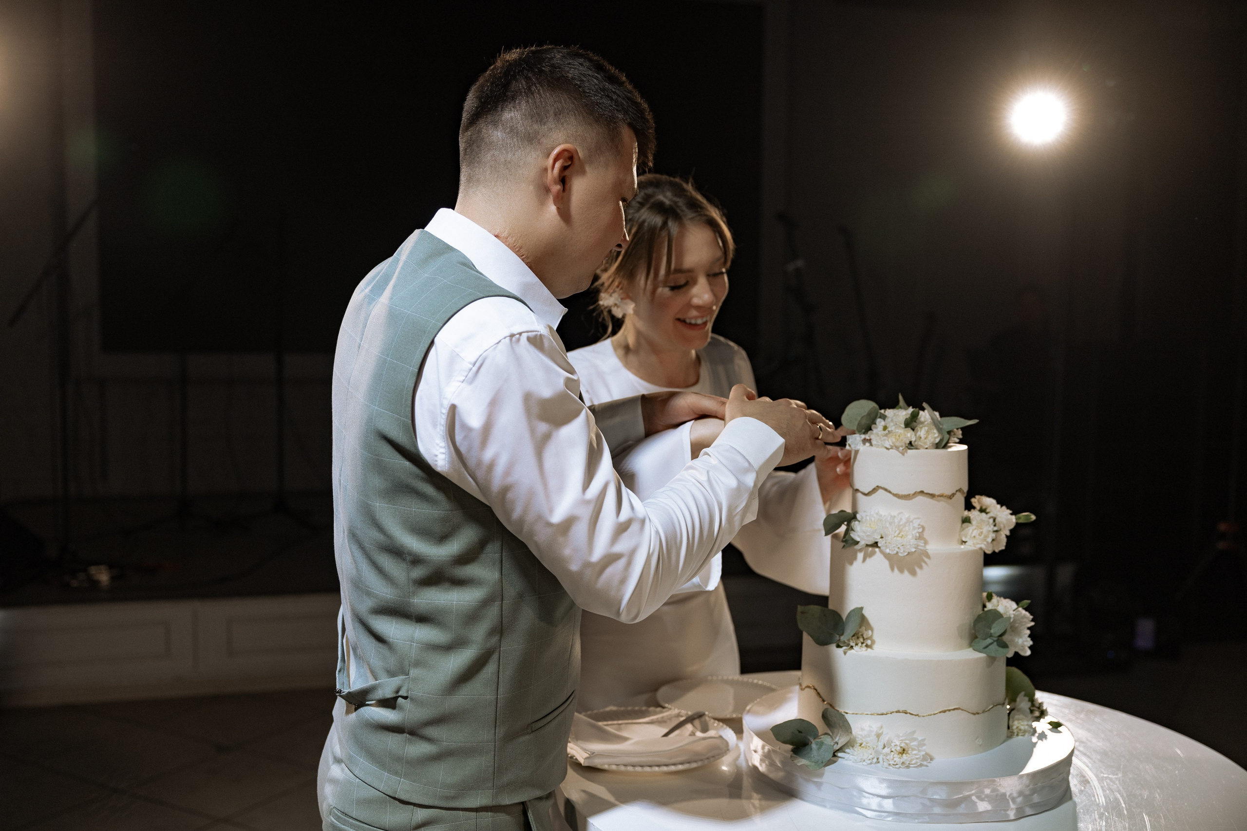 Жених и невеста режут свадебный торт в Красноярске