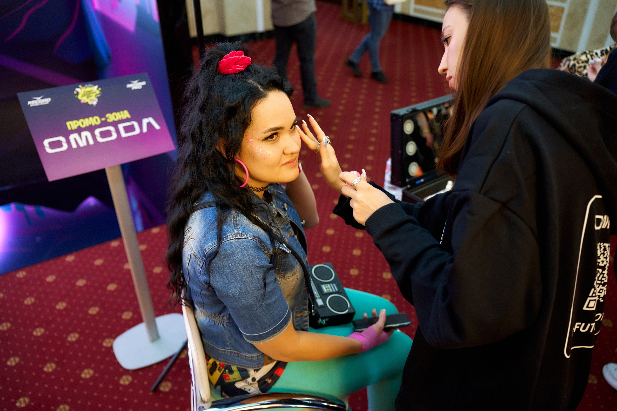 Промоутер OMODA с планшетом общается с гостьей — промо-зона Корстон Казань
