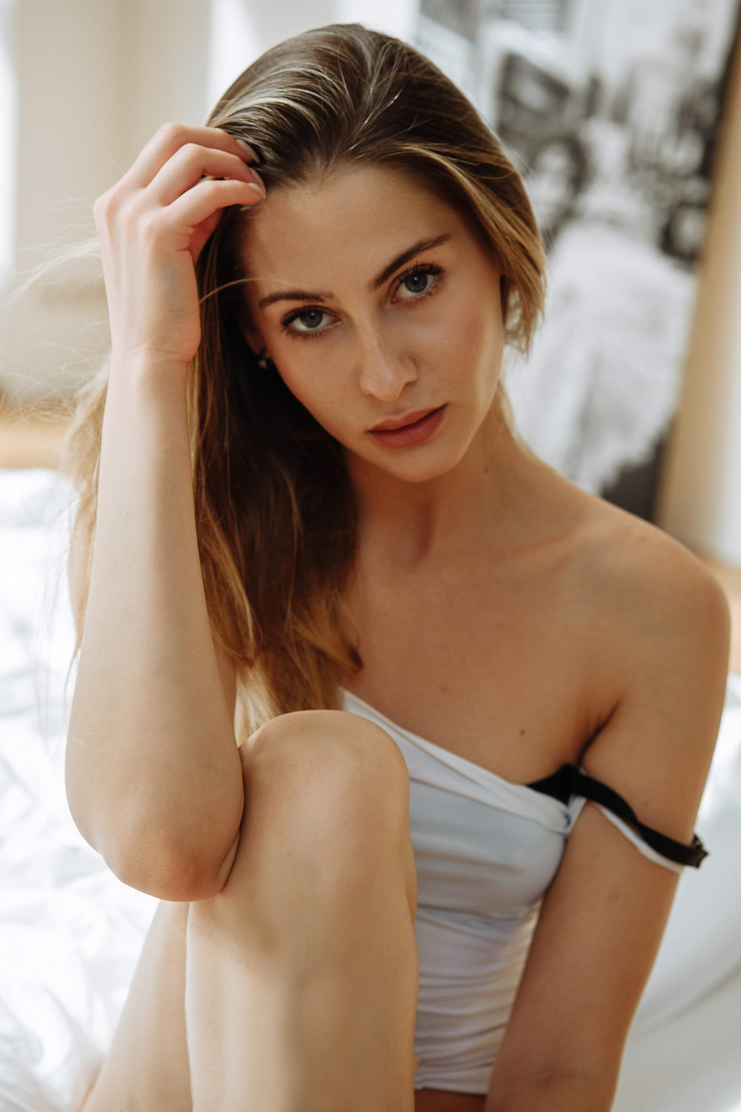 Девушка в белье фотографируется на кровати