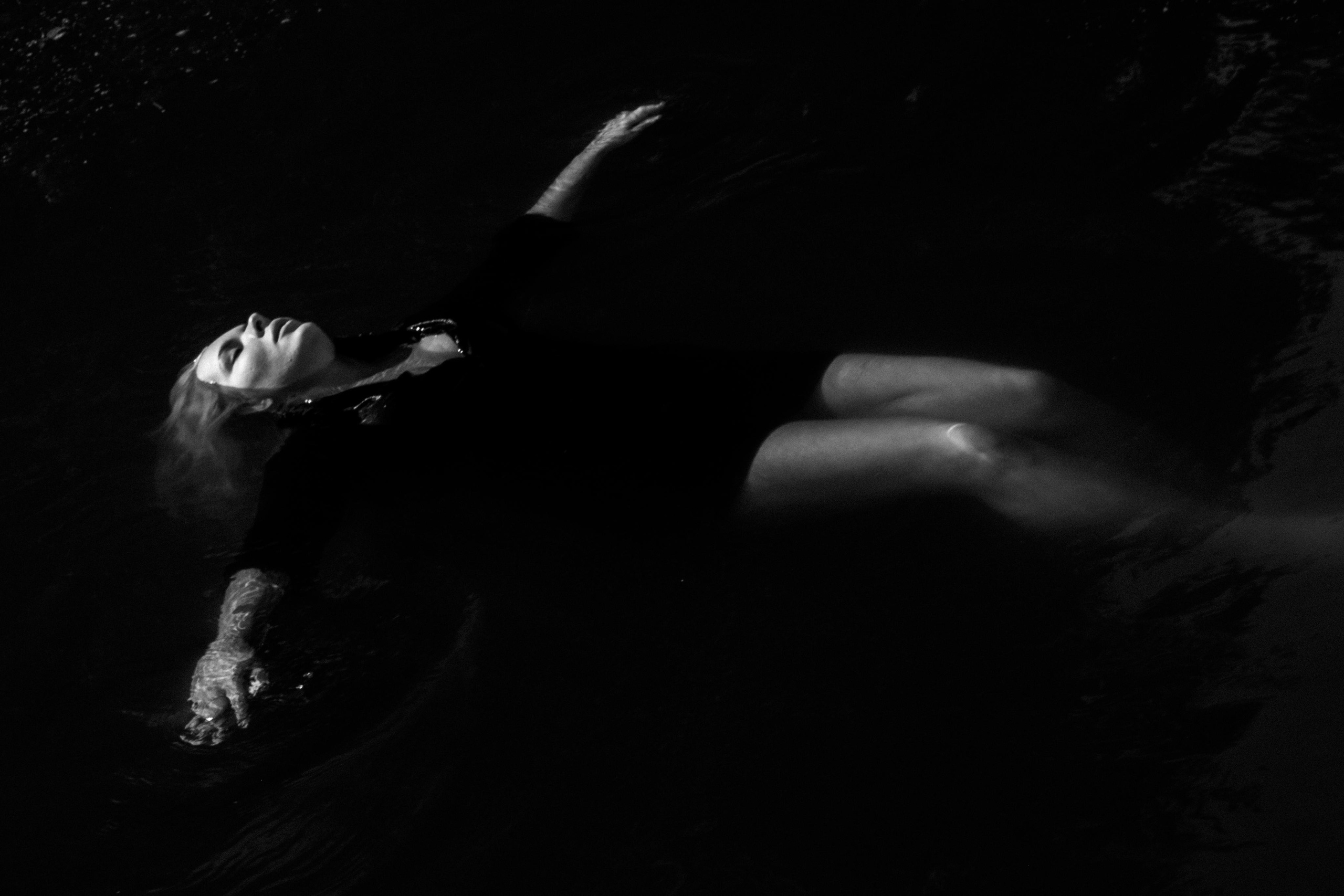 черно-белая фотография девушки, которая лежит на воде