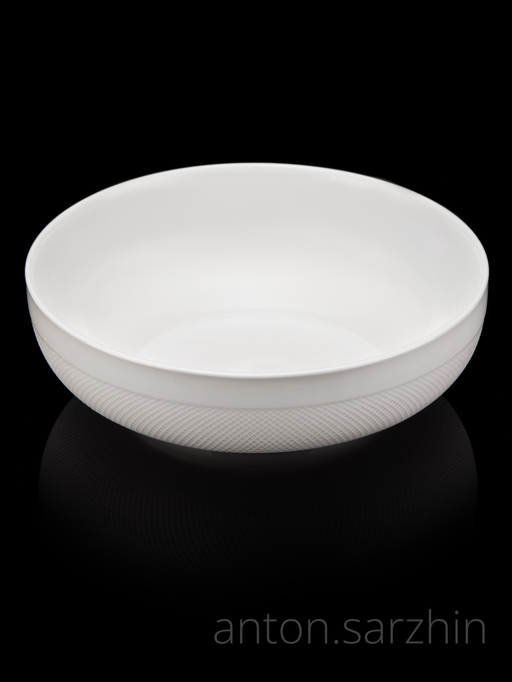Предметная съемка белой тарелки на черном фоне