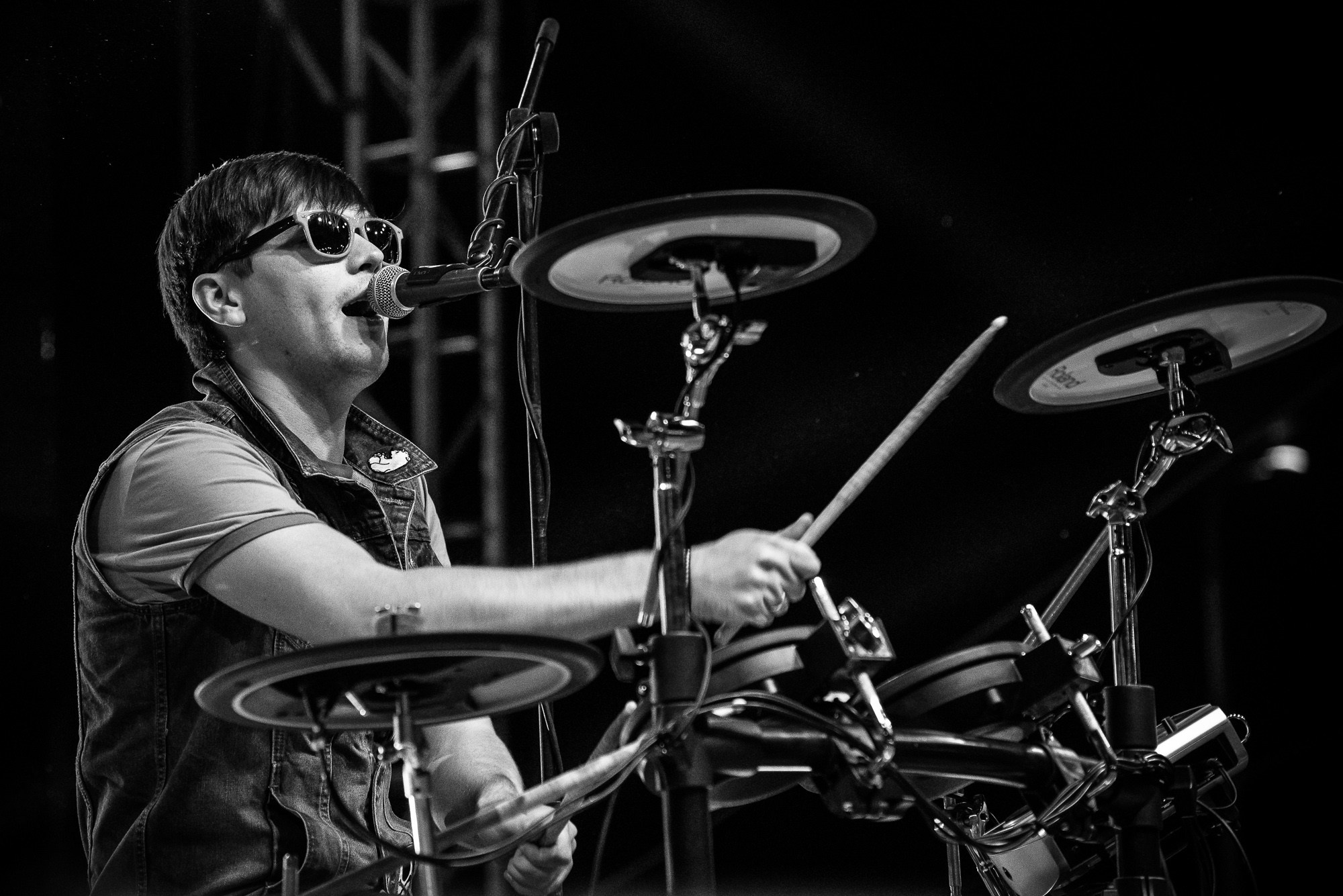 Барабанщик поёт песню и играет на барабанах во время концерта