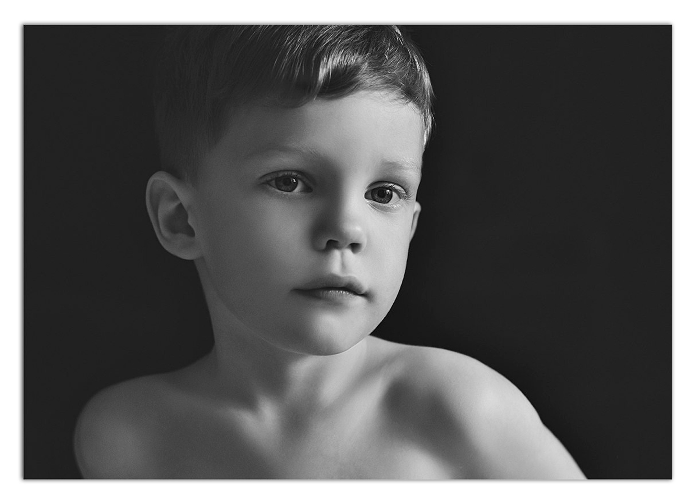 Детская фотосъемка в студии - портрет мальчика без рубашки на тёмномфоне.