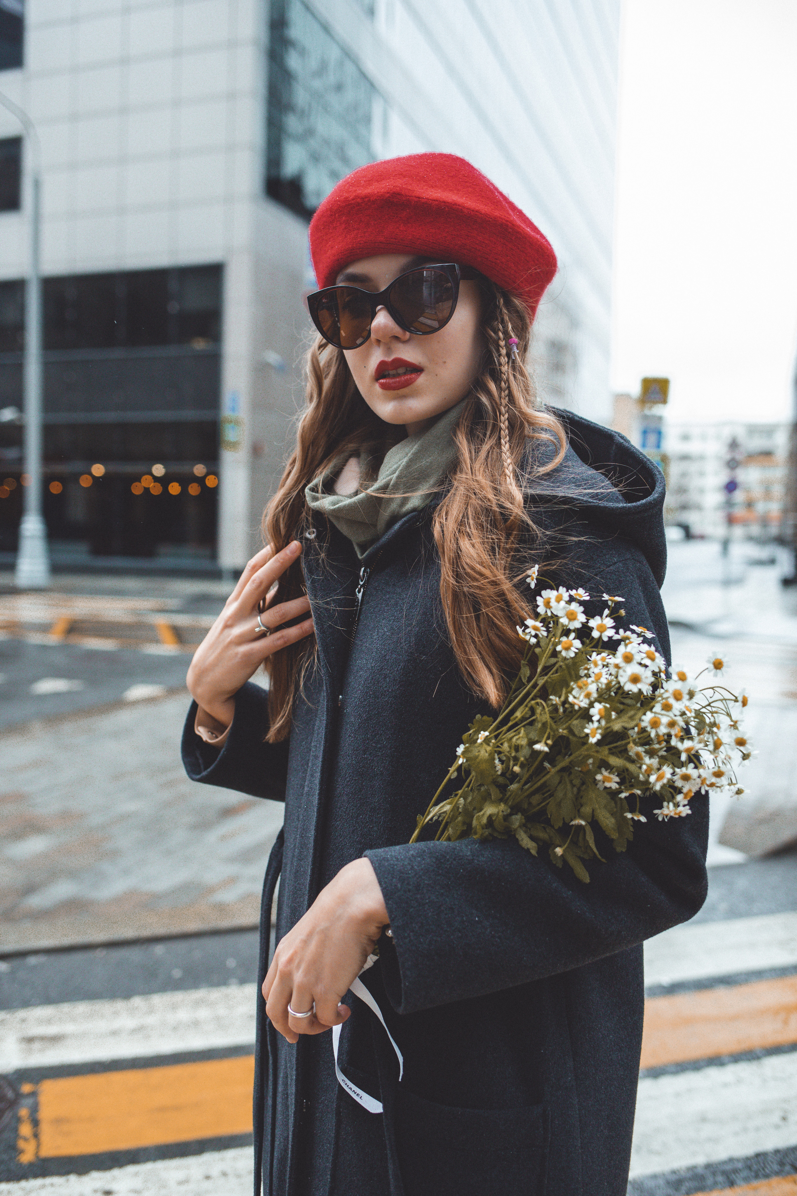 Девушка в красном берете с букетом ромашек в центре Москвы