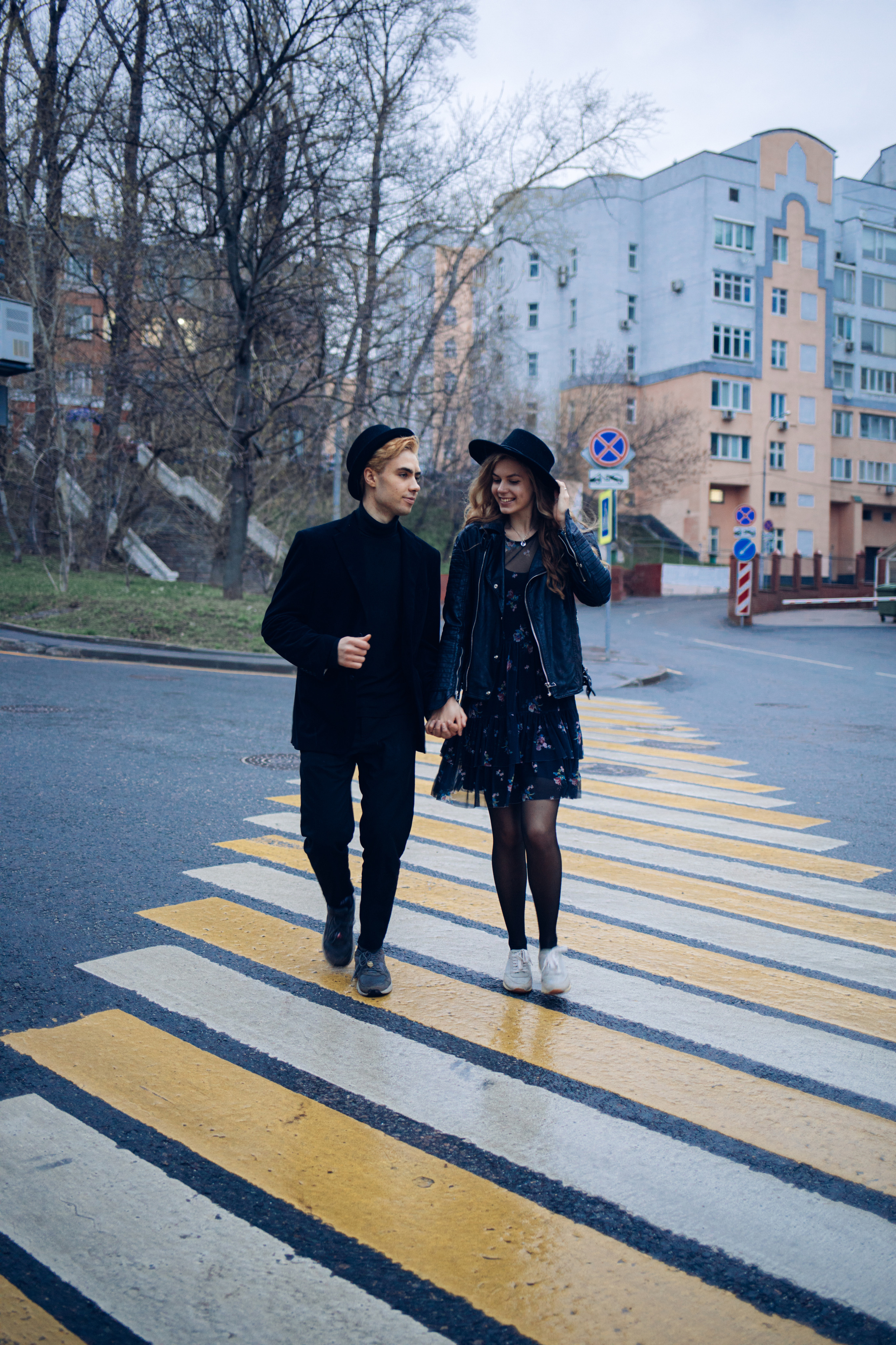 Влюбленная пара бежит по пешеходному переходу в дождливую погоду в Москве