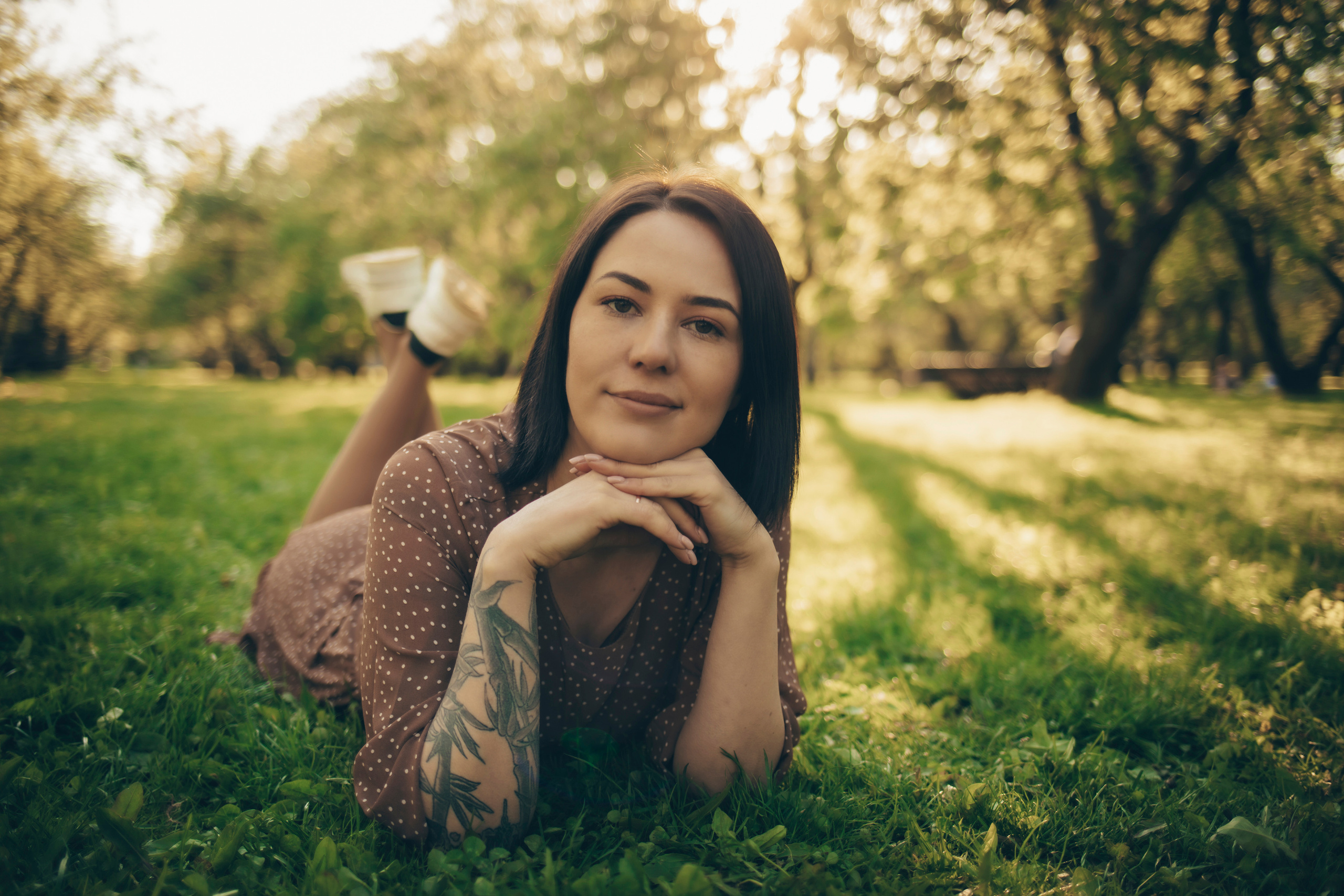 Девушка летняя красивая в яблоневом саду в Коломенском лежит на траве