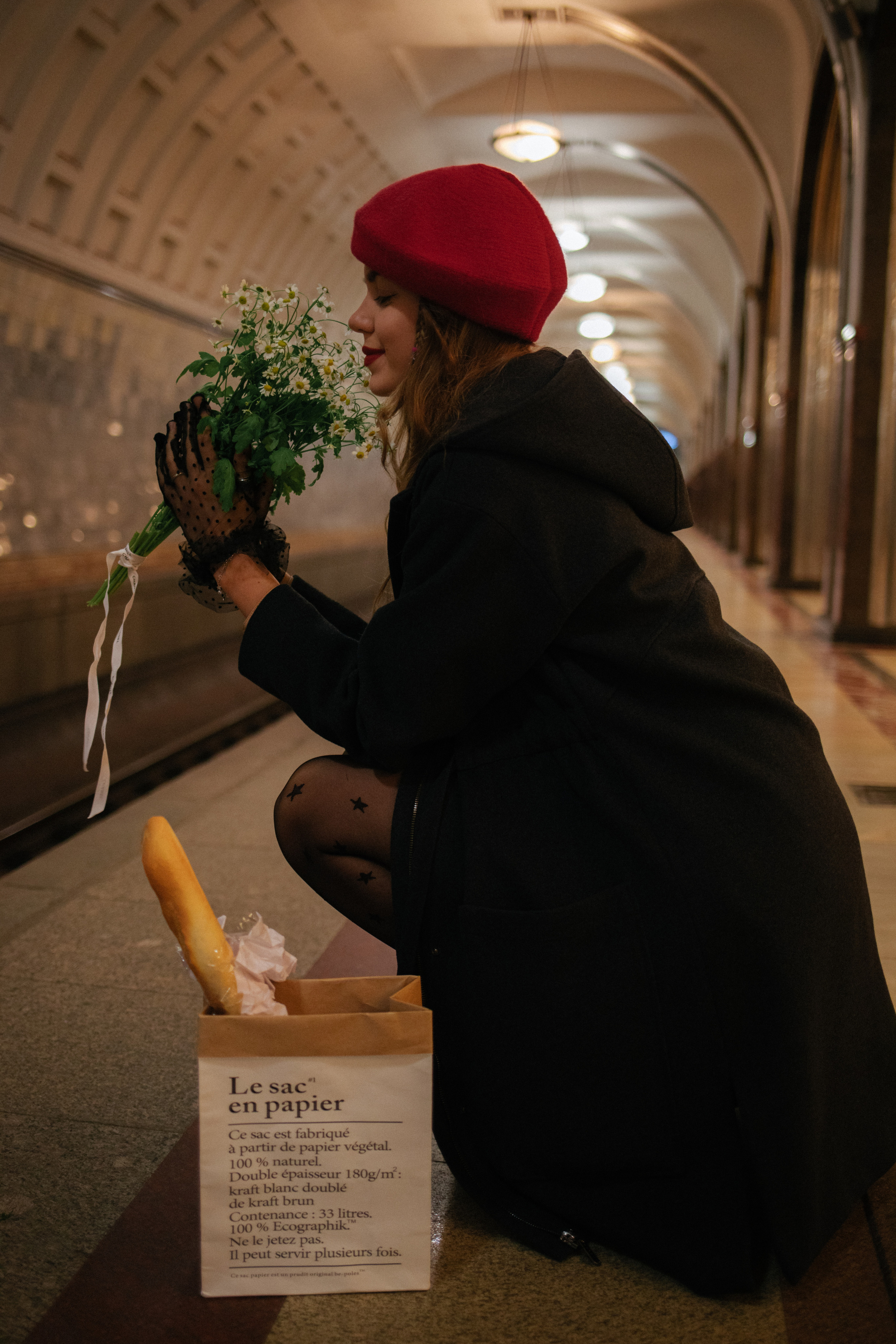 Девушка с багетом и ромашками и в красном берете в московском метро 