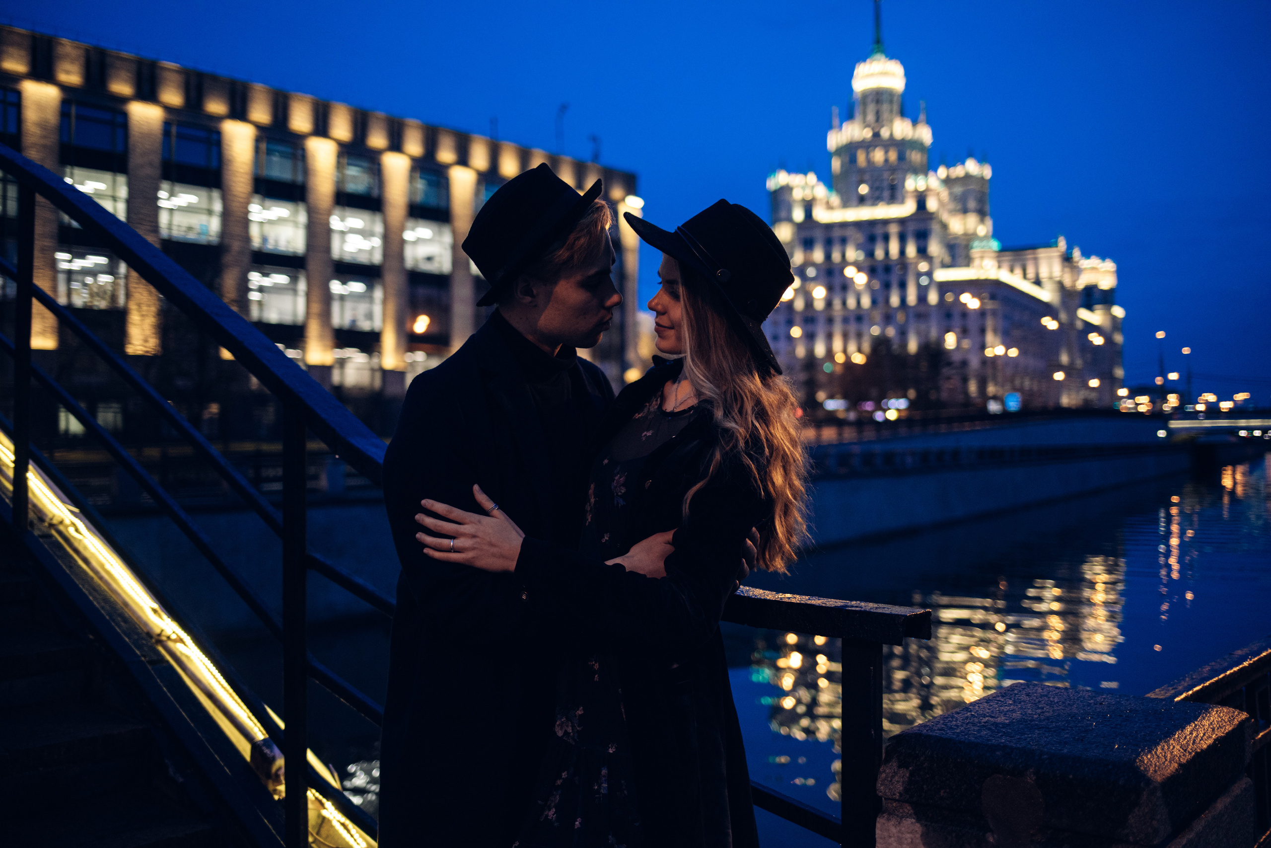 Влюбленная пара обнимается с видом на ночную Москву