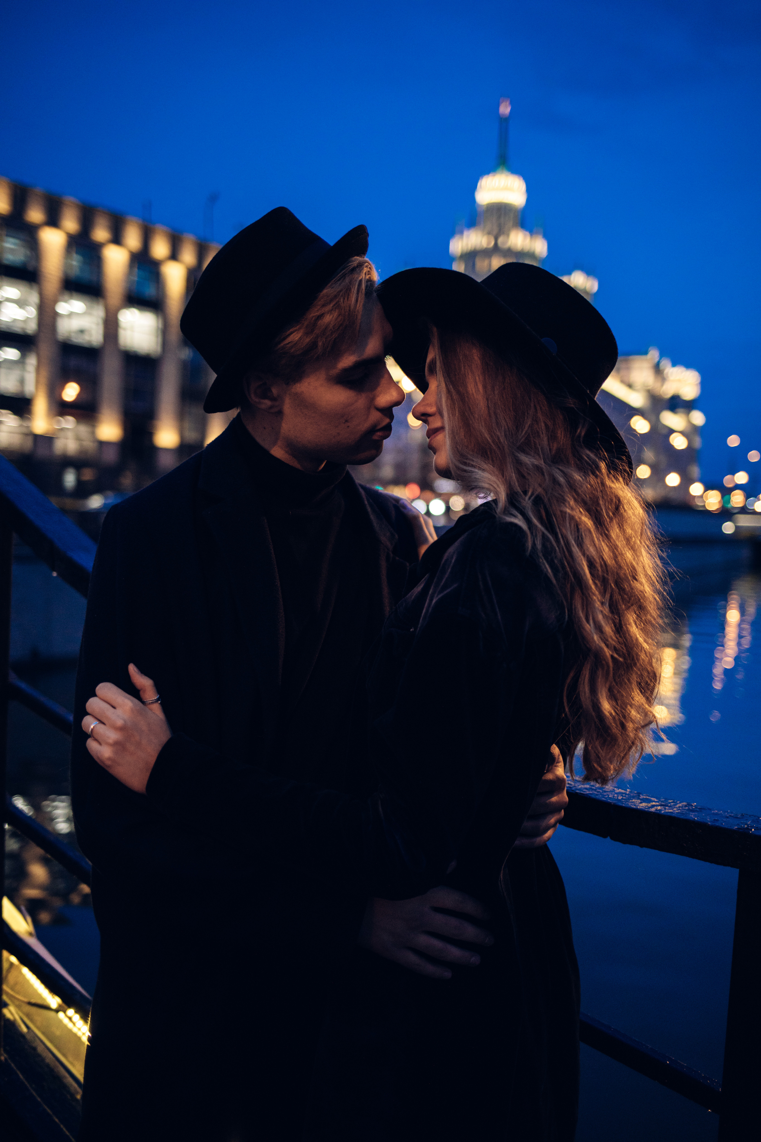 Влюбленная пара обнимается с видом на ночную Москву