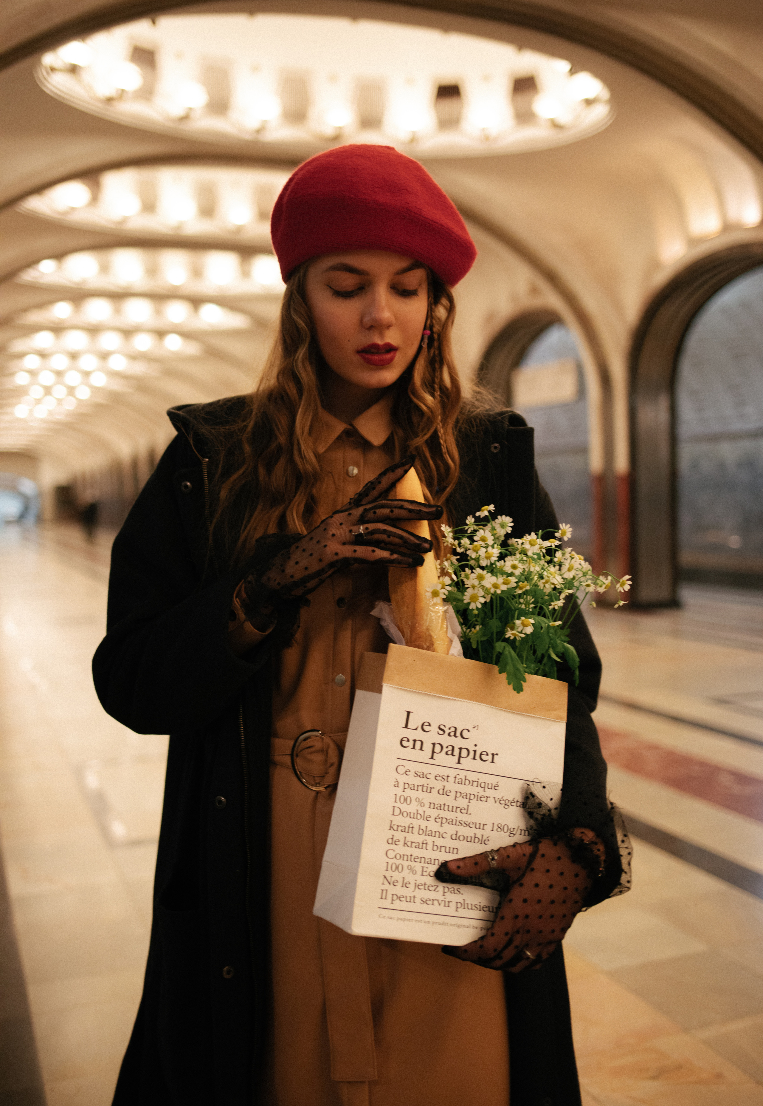 Девушка с багетом и ромашками и в красном берете в московском метро 