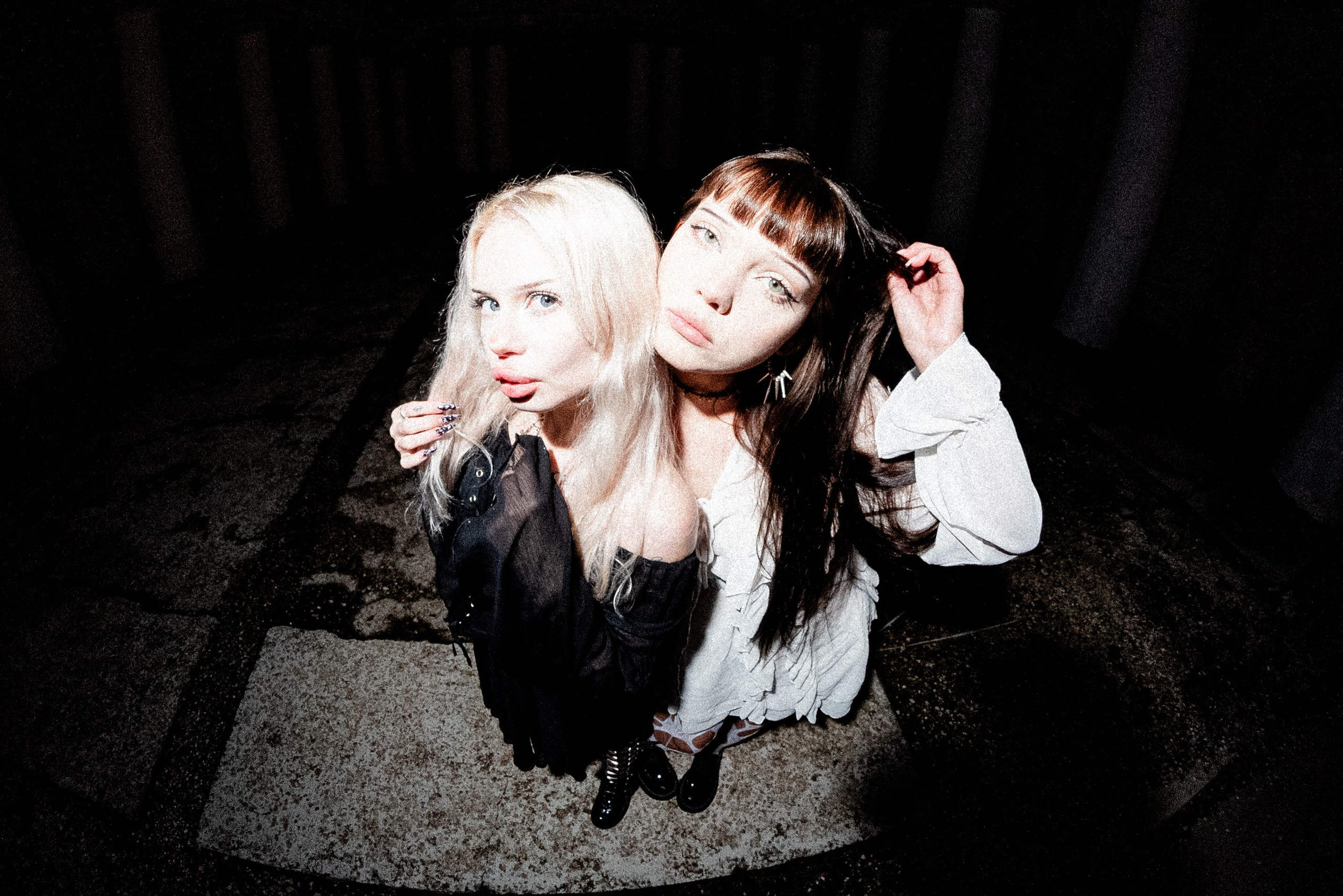 Портрет двух альт шик девушек на объектив рыбий глаз со вспышкой в лоб одна девушка в чёрном платье блондинка другая девушка в белом платье брюнетка