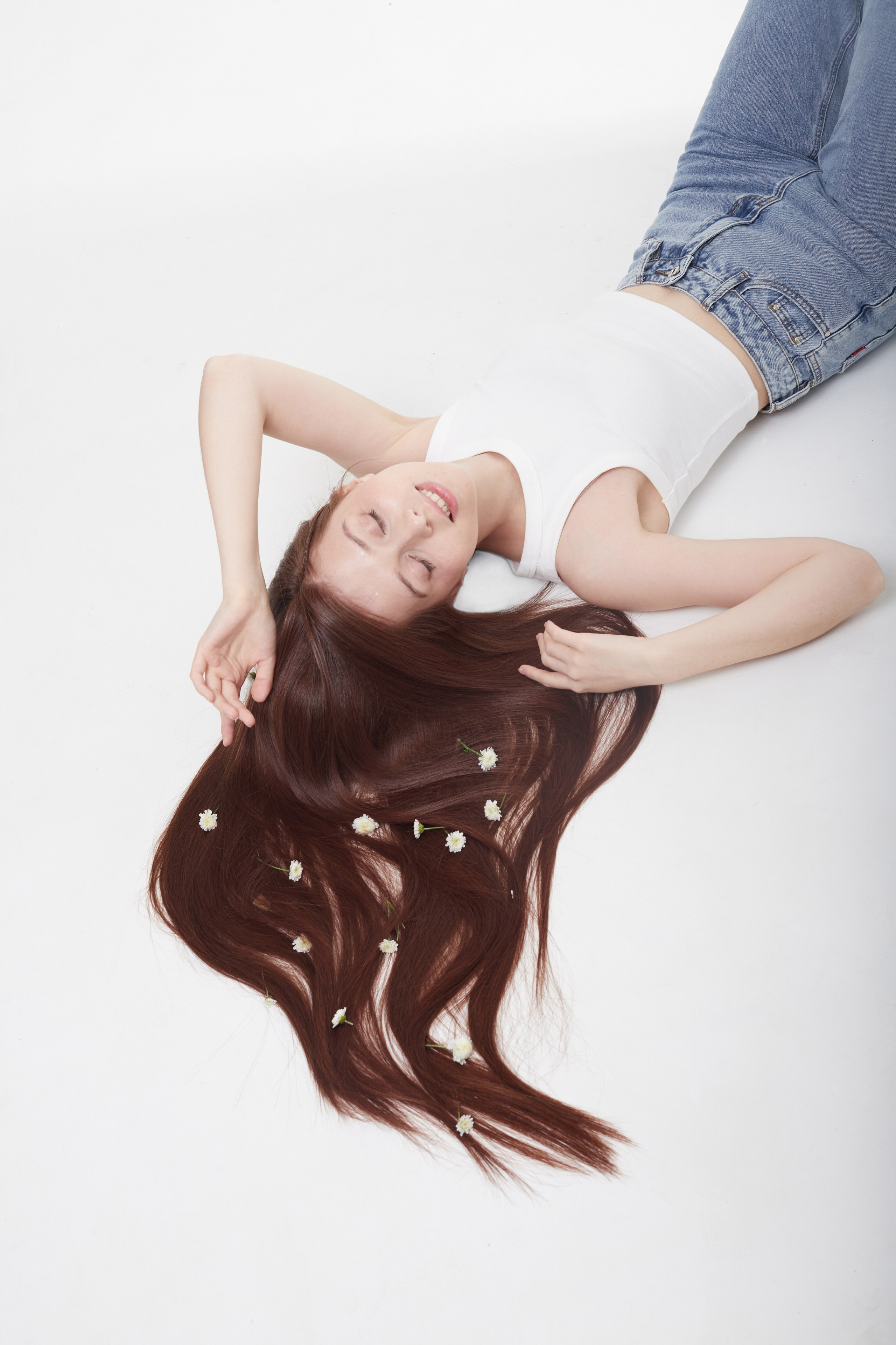 Студийная фотосъёмка девушки с длинными волосами в позе лёжа.