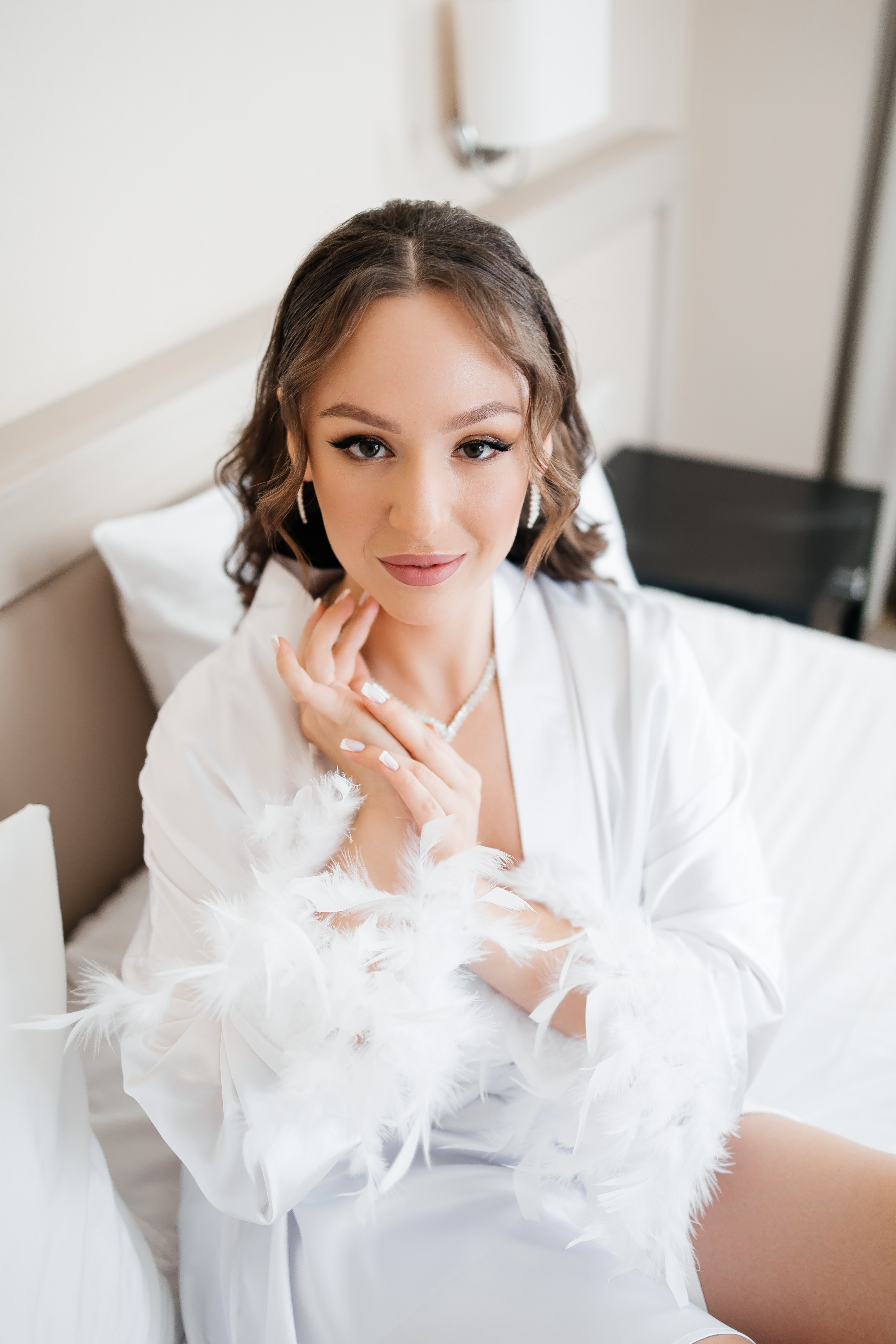 Красивая невеста в халате перед свадьбой в отеле