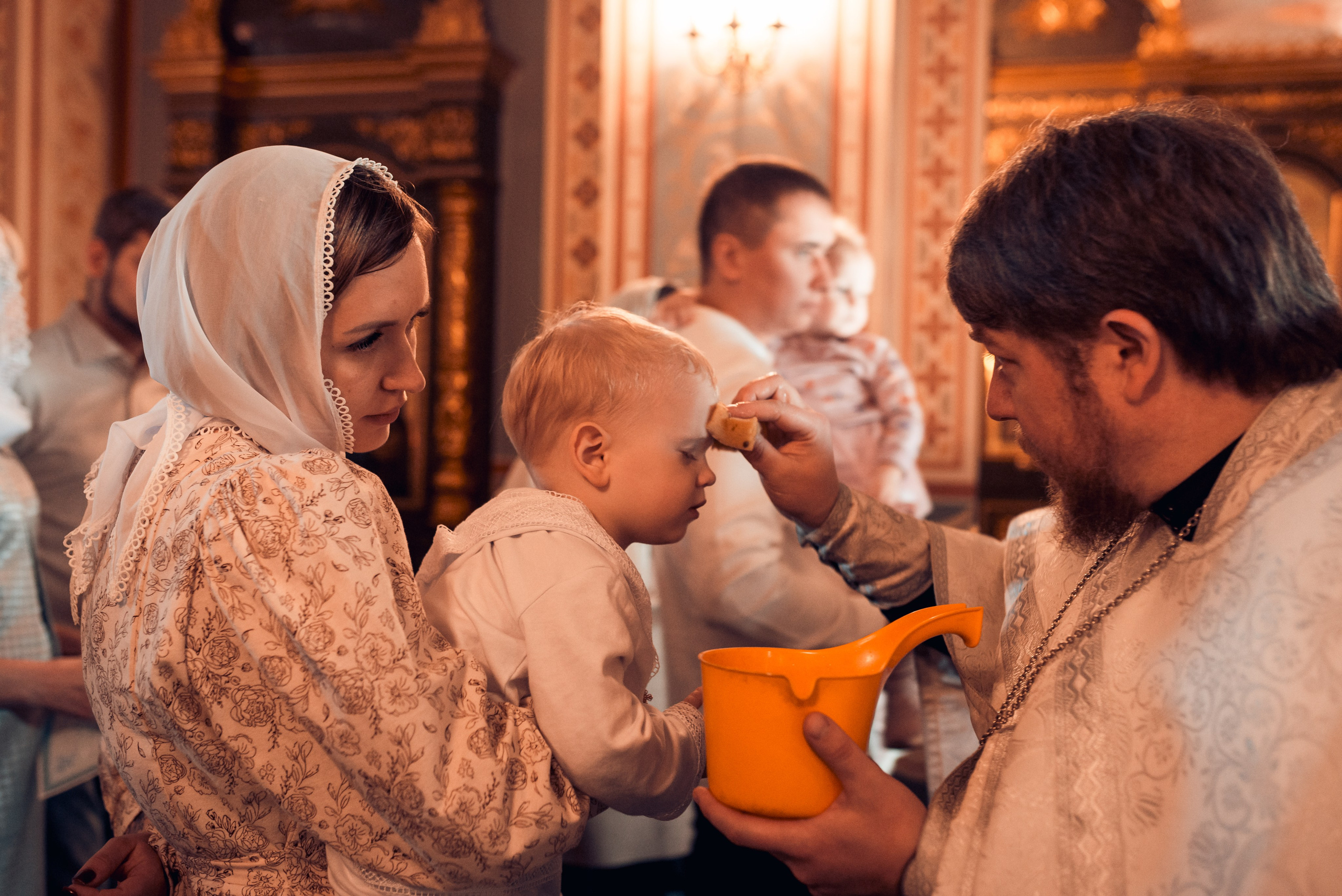 Момент таинства Миропомазания, священник и ребенок в церкви, съемка крещения в Новосибирске