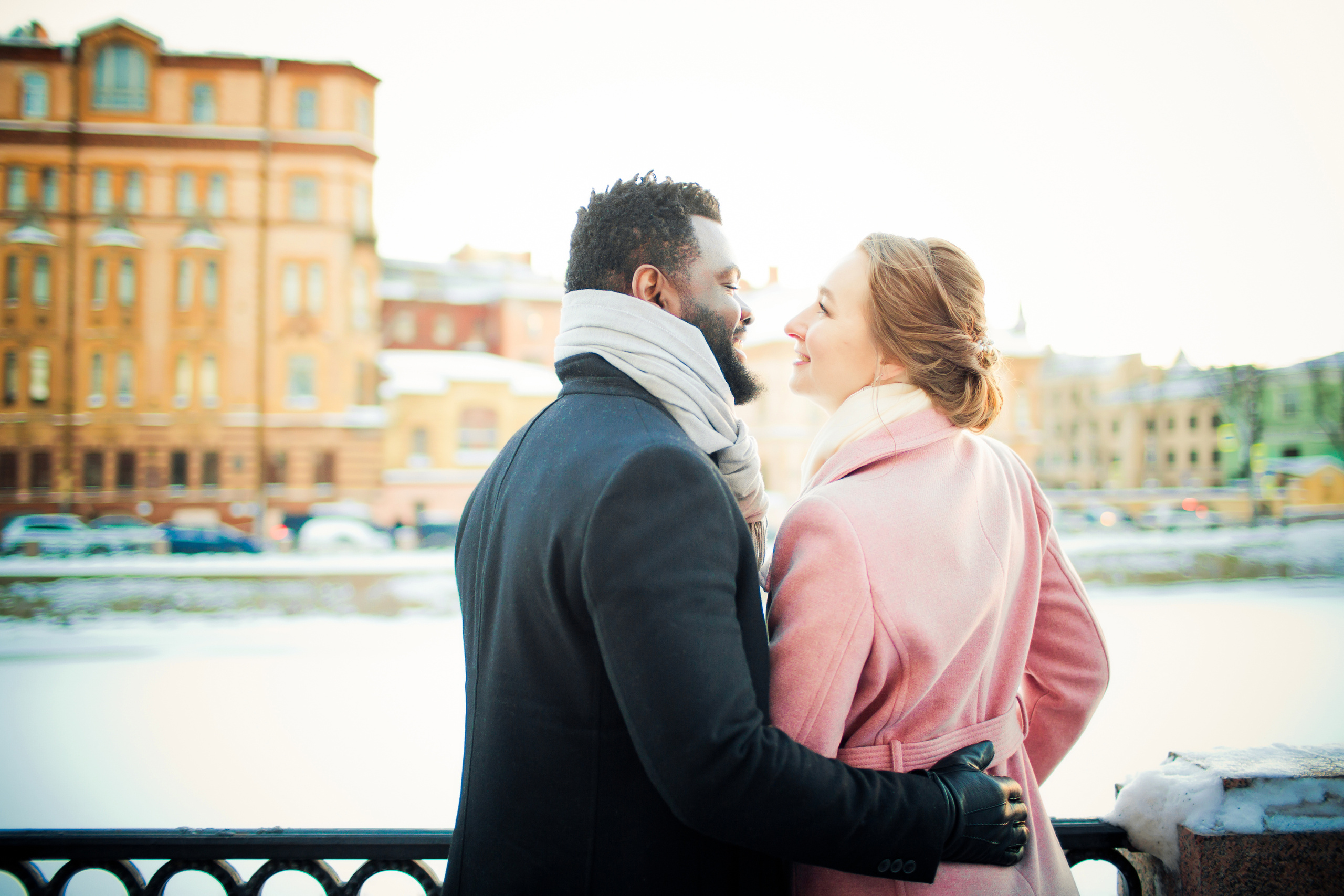 влюбленные тянутся друг к другу на зимней набережной