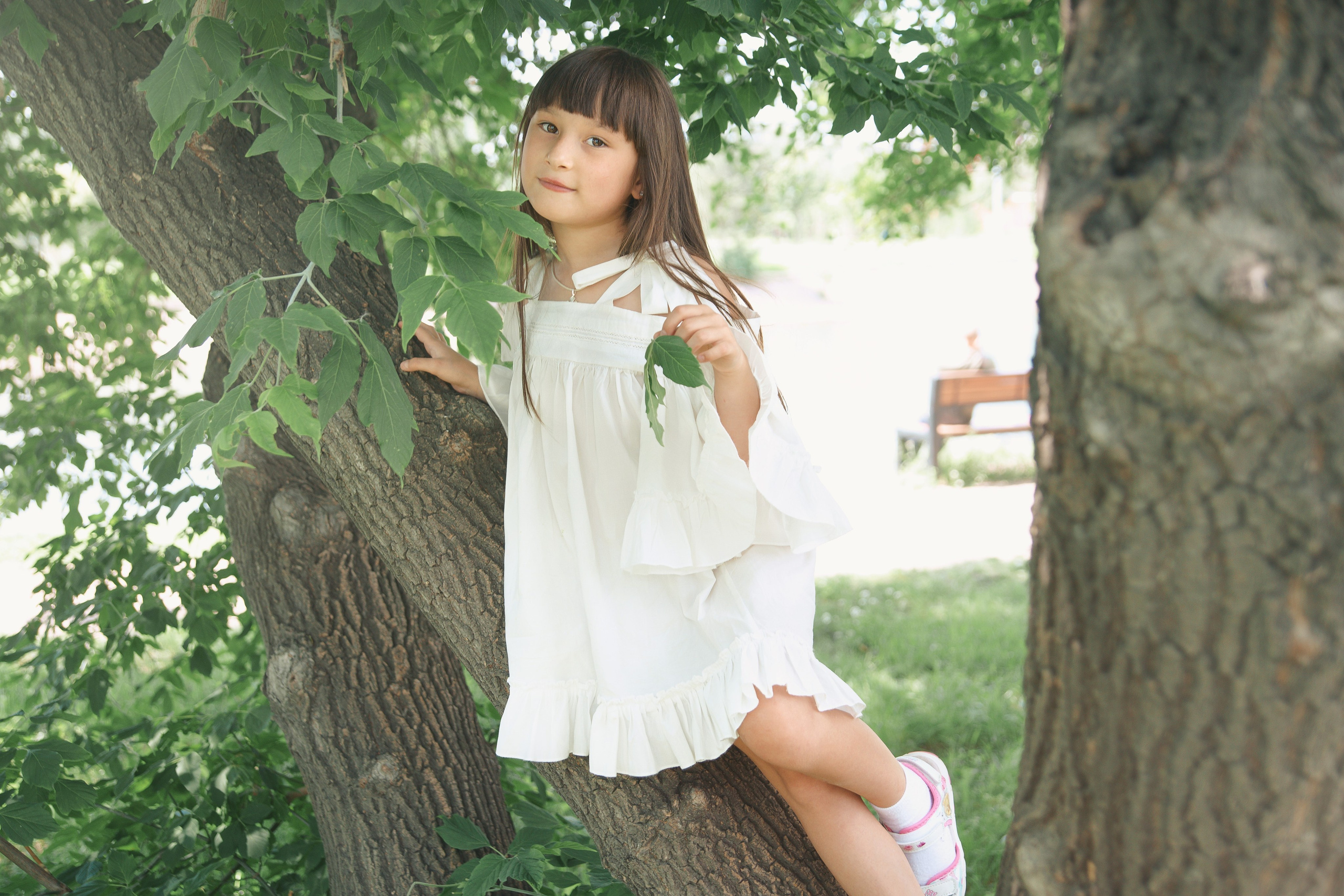 Детская фотосессия летом - девочка стоя на дереве