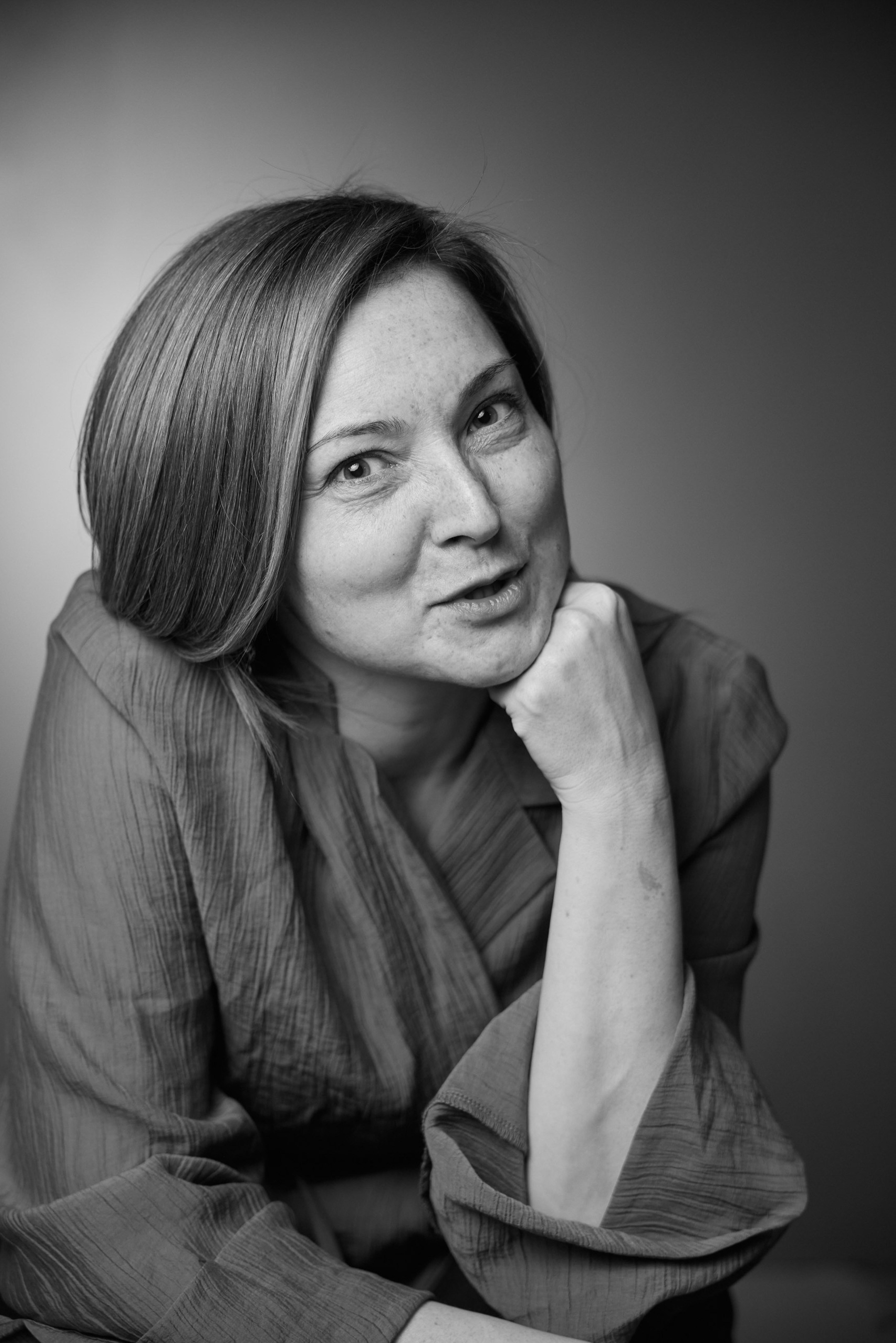 Black and white emotional portrait of a young woman against a grey studio background - photographer Andrey Dunin