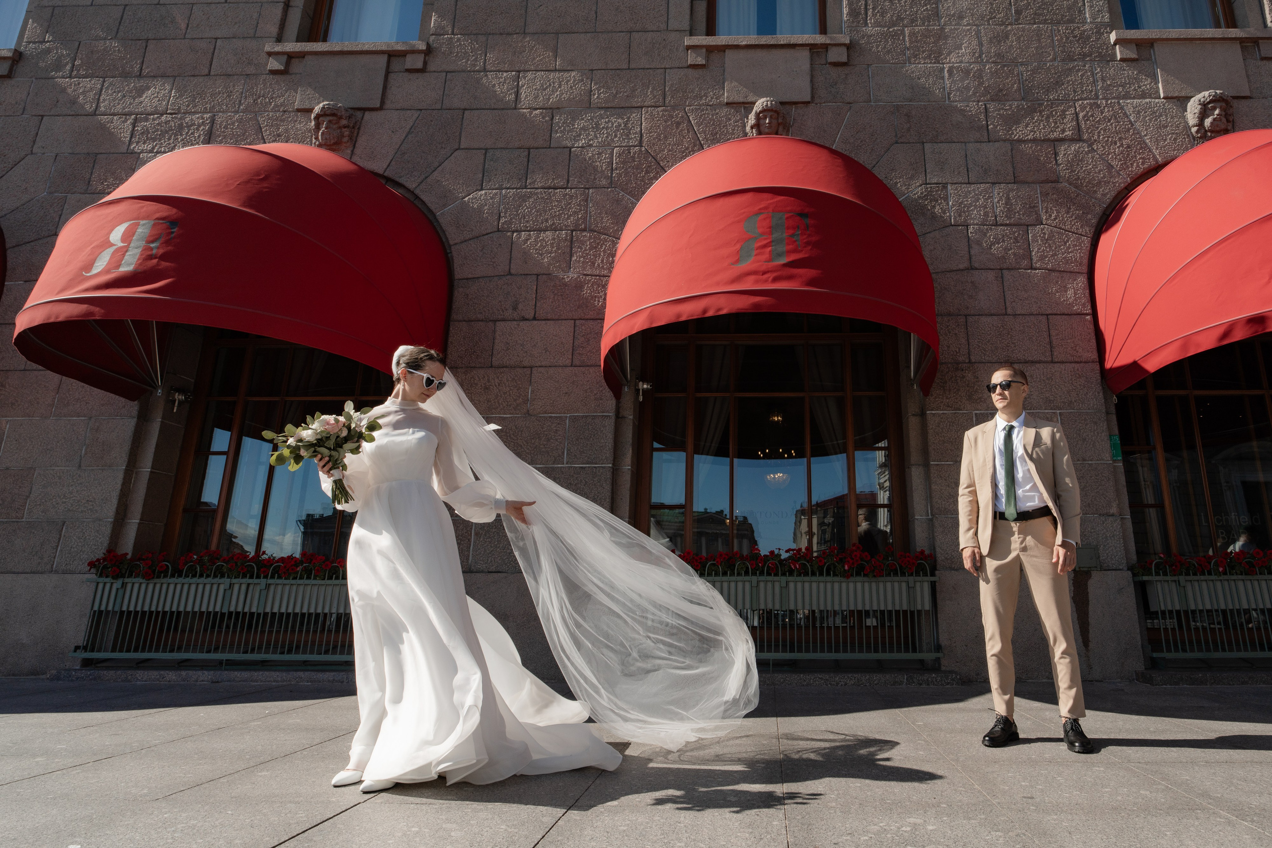 жених и невеста стоят у окон гостиницы Астория в Санкт-Петербурге на свадебной фотосессии. Свадебная фотосессия у Астории.