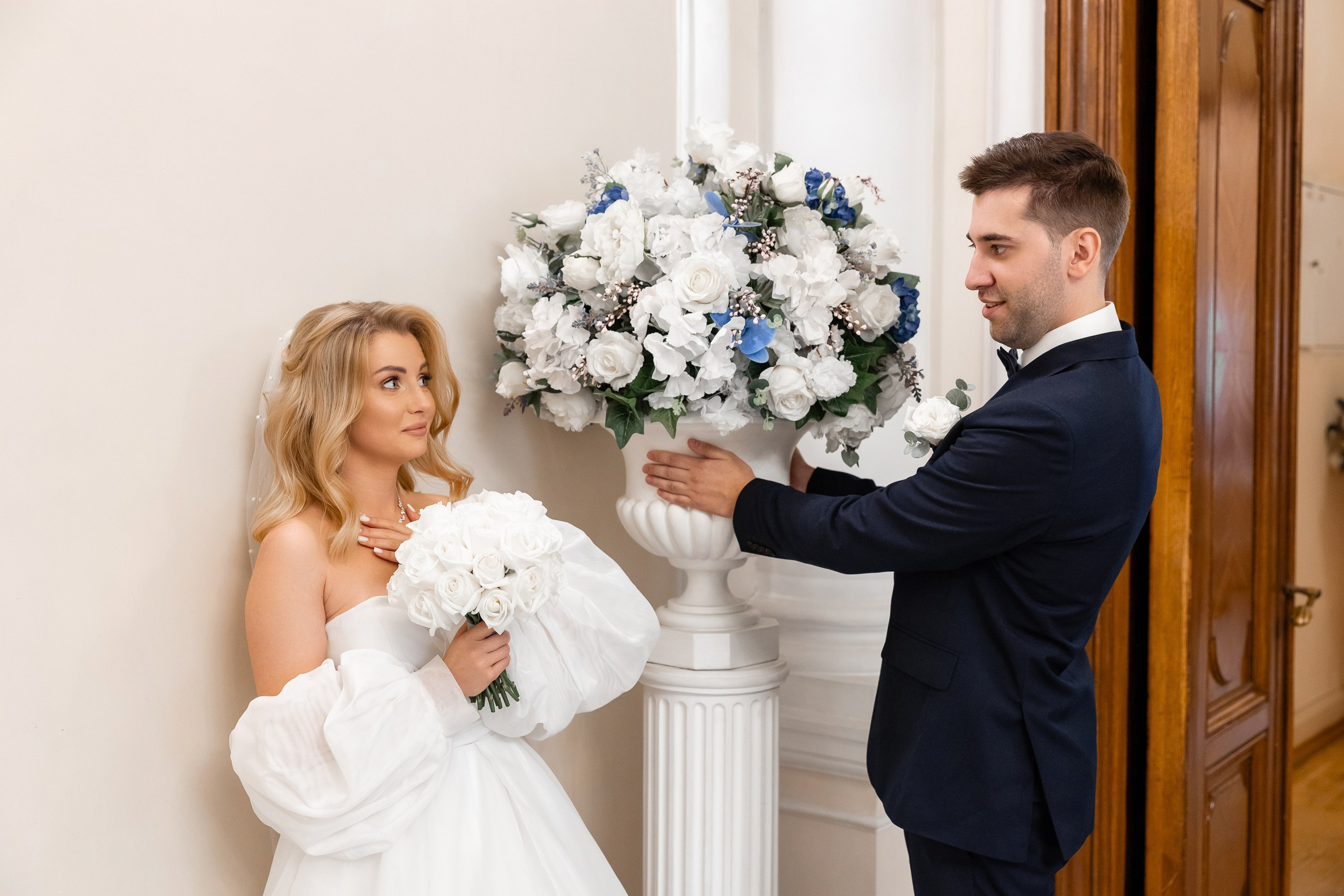 Жених дарит вазу с цветами невесте