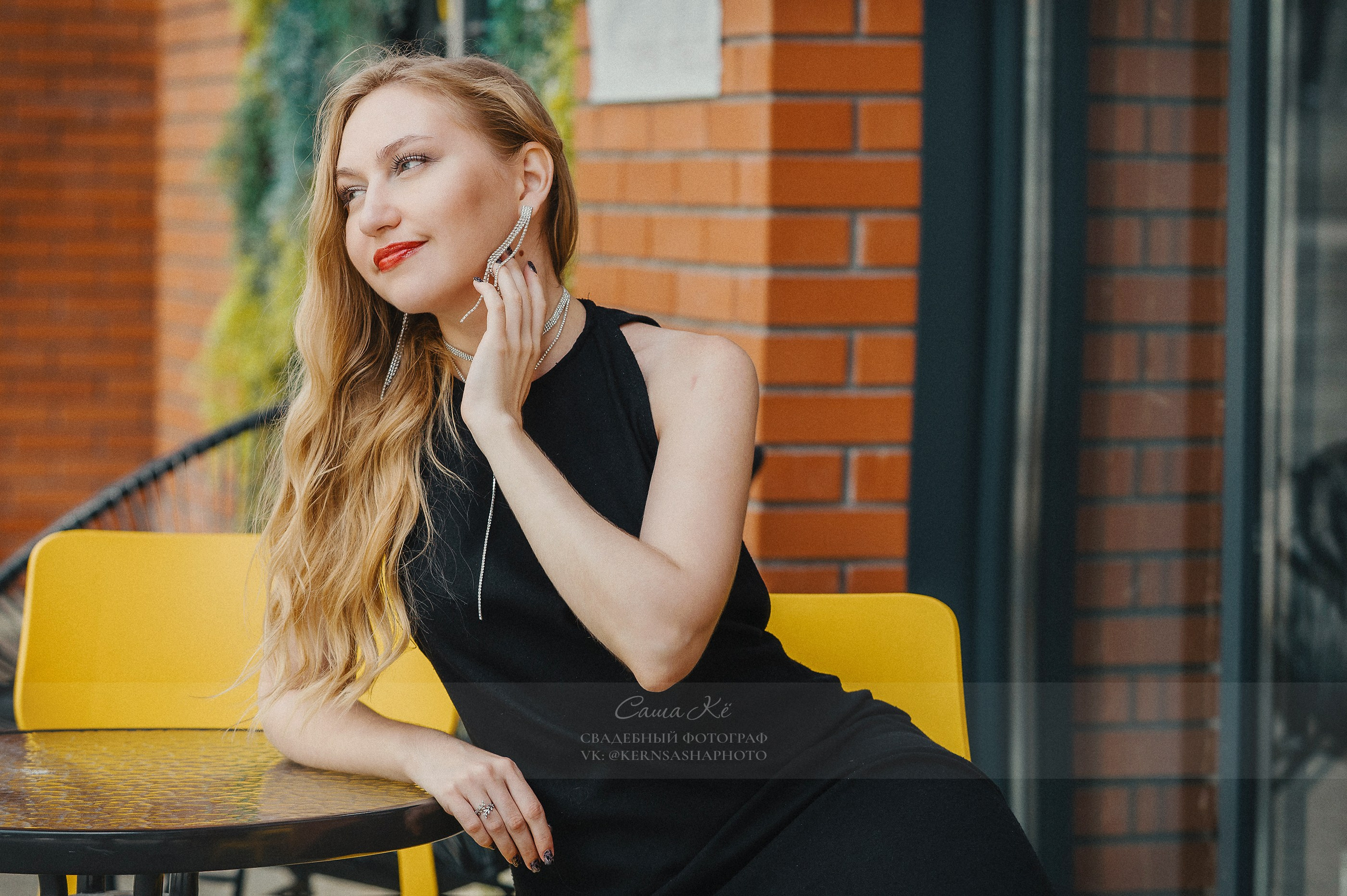 Невеста в фате смеётся, жених смотрит на неё