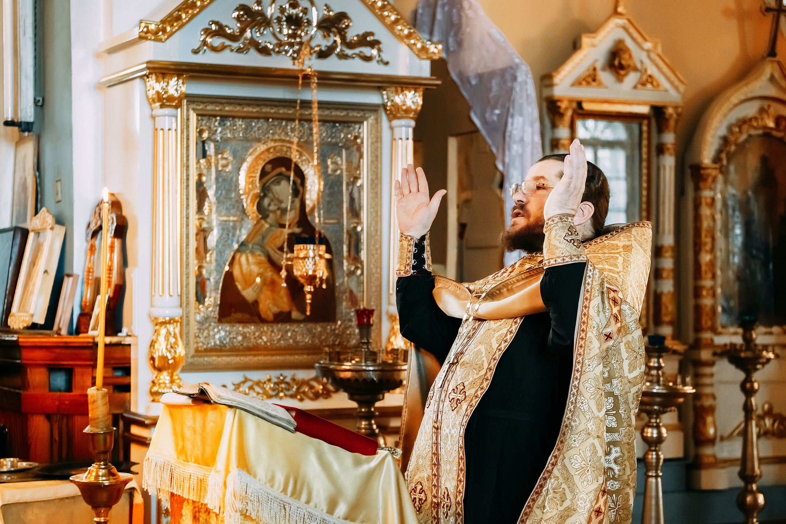 священник читает молитву на таинстве Венчания