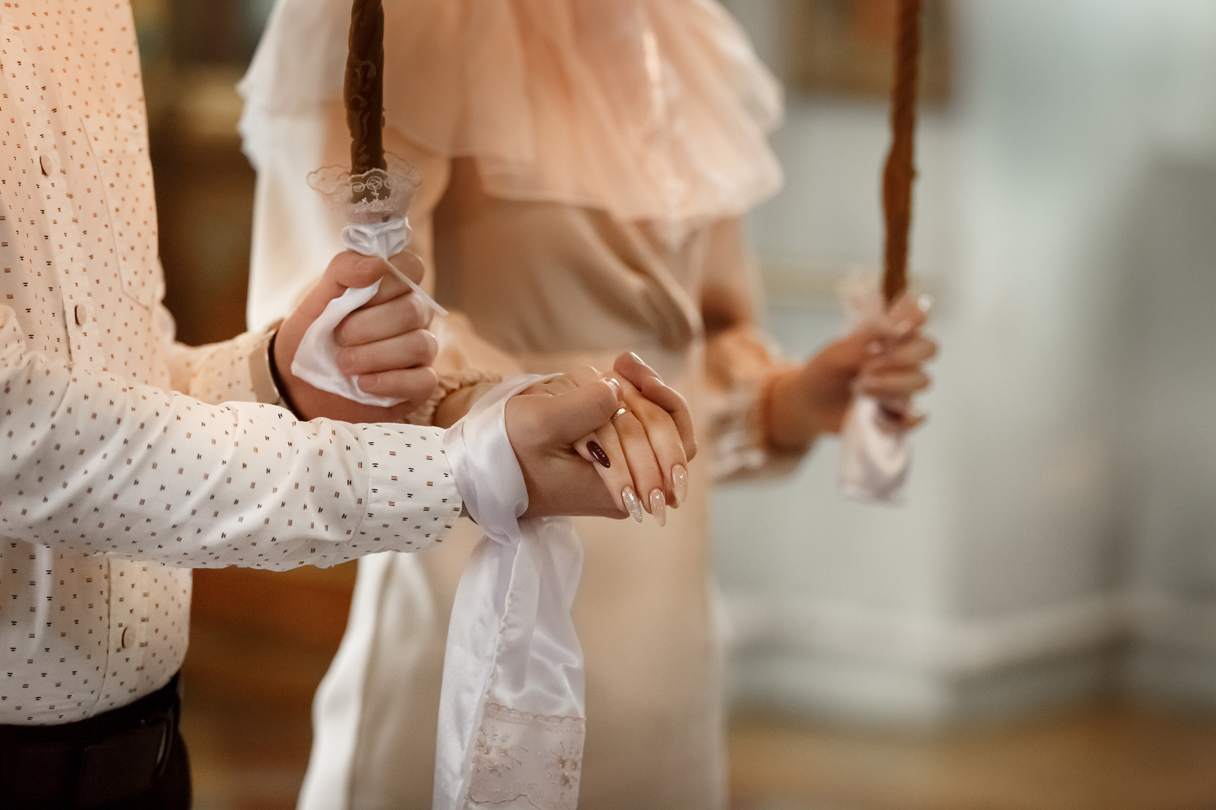 священник соединяет правую руку мужа с правой рукой жены