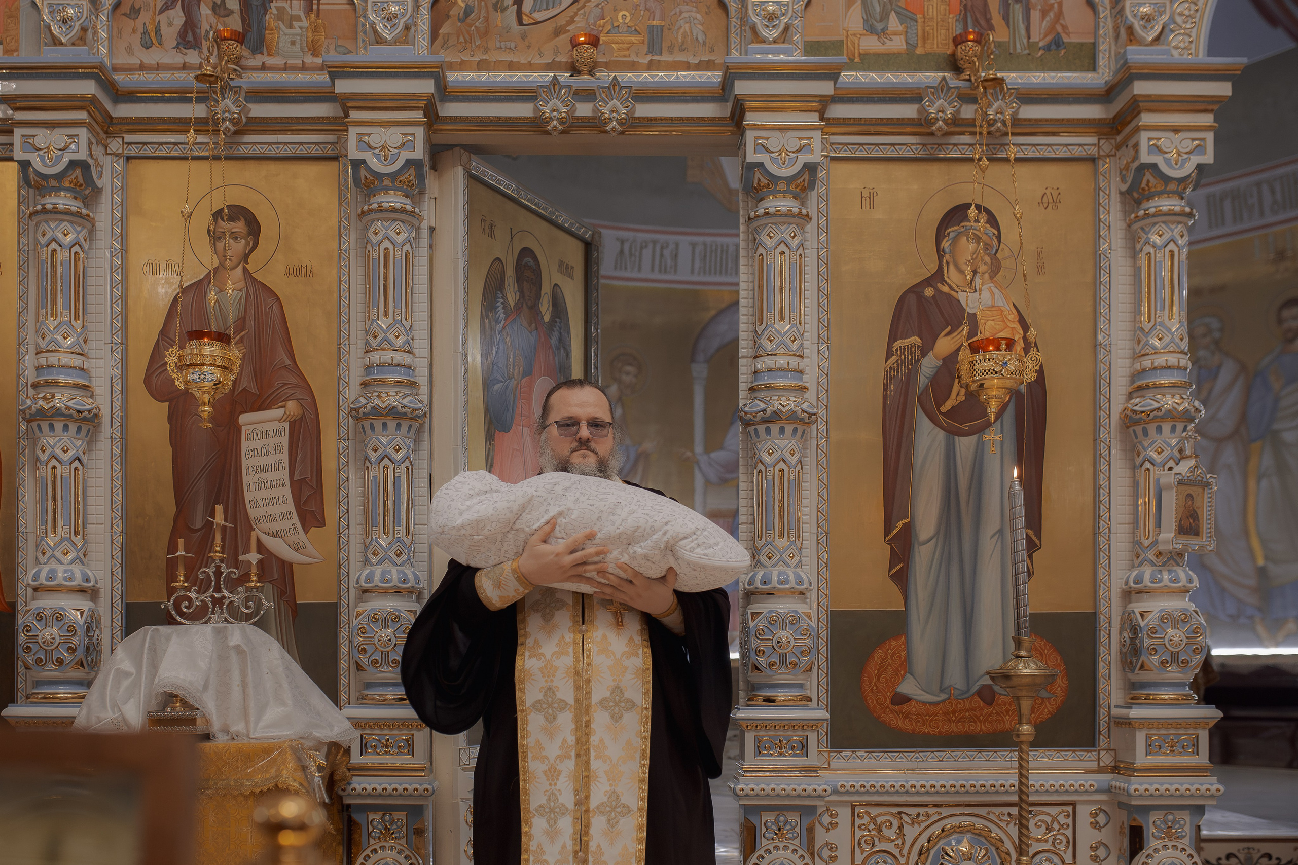 Иеромонах Михаил (Столяров) выносит ребенка из алтаря Успенского собора в Ташкенте после воцерковления