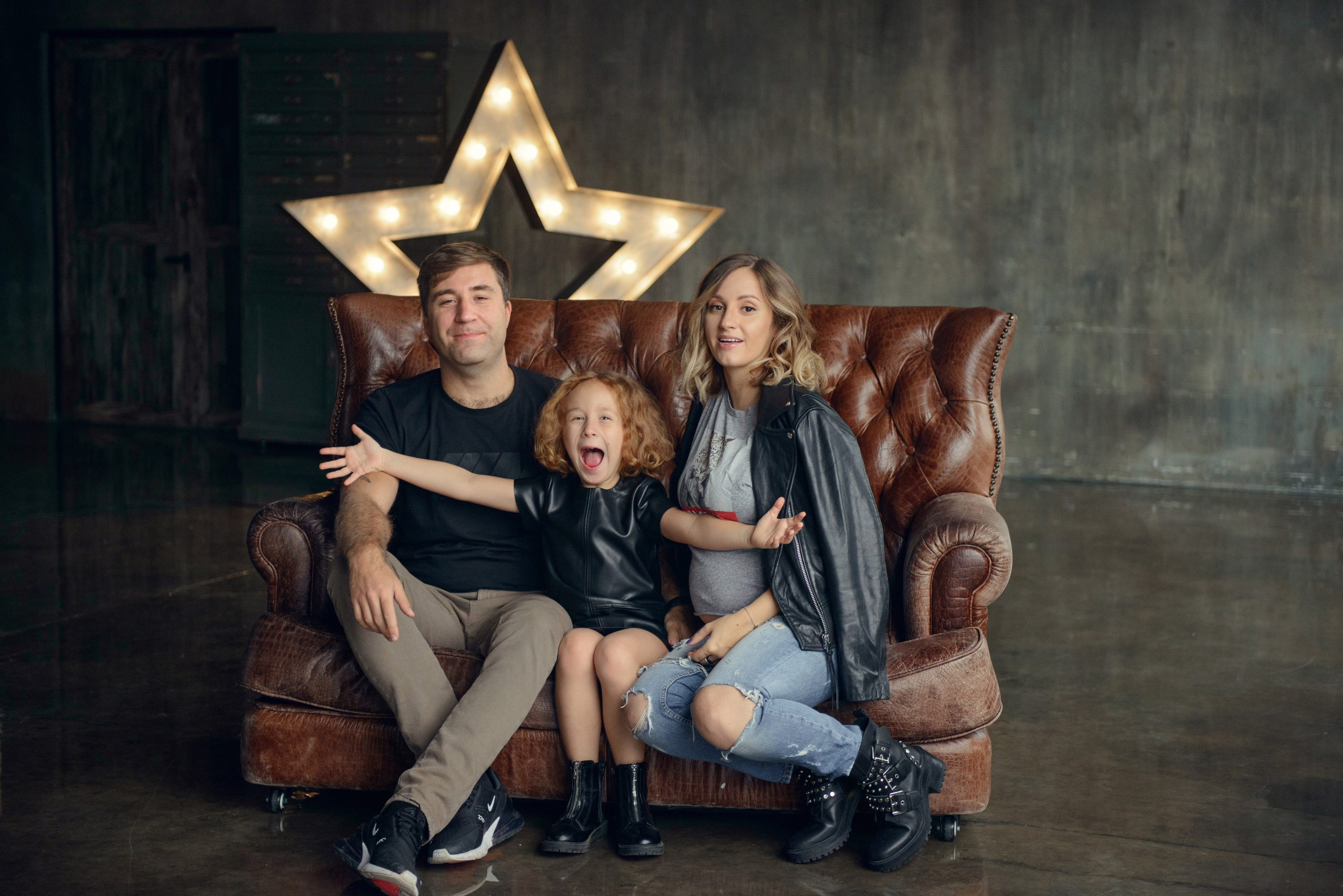 Family photo shoot with a pregnant woman in a loft studio, rock and roll style