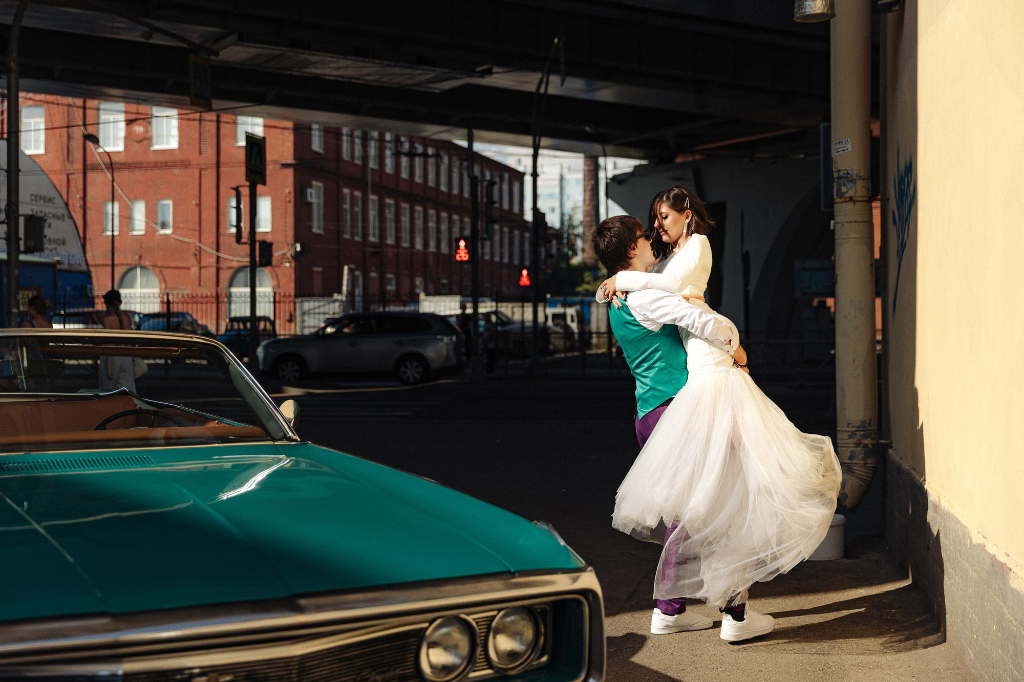 Жених кружит невесту возле машины