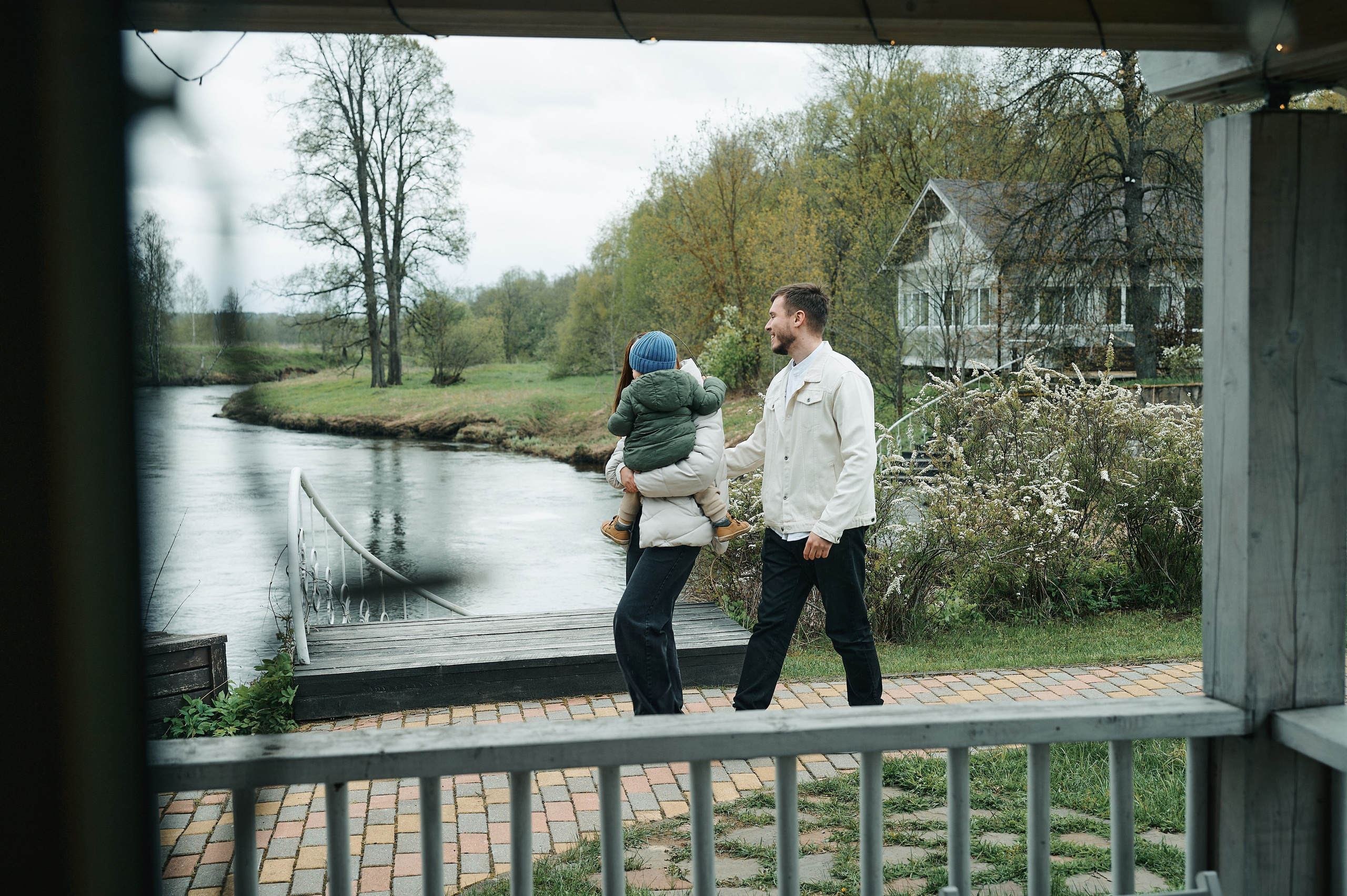 вид на семью, идущую вдоль реки, снято из деревянной беседки